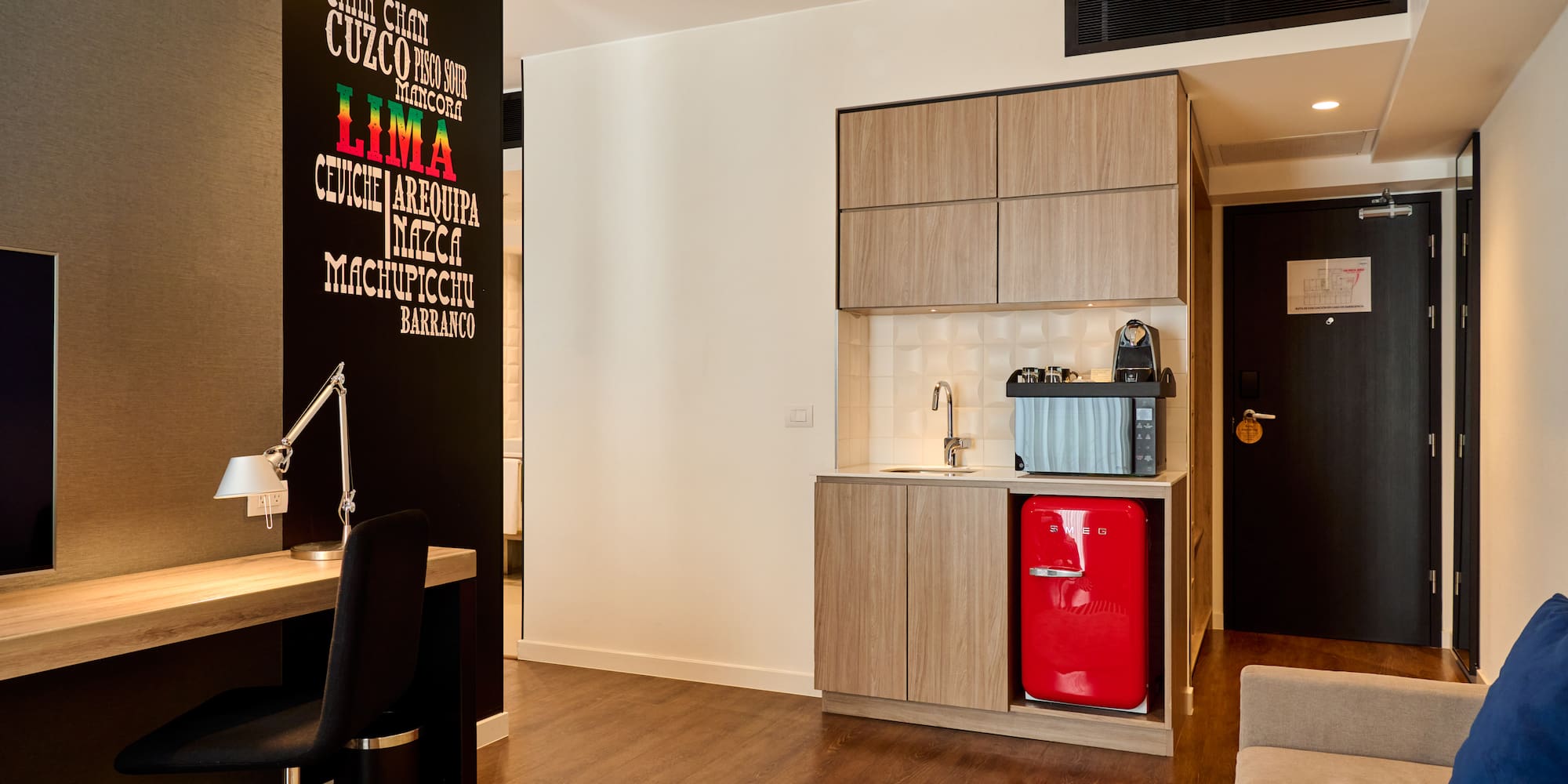 a room with a red refrigerator and a desk