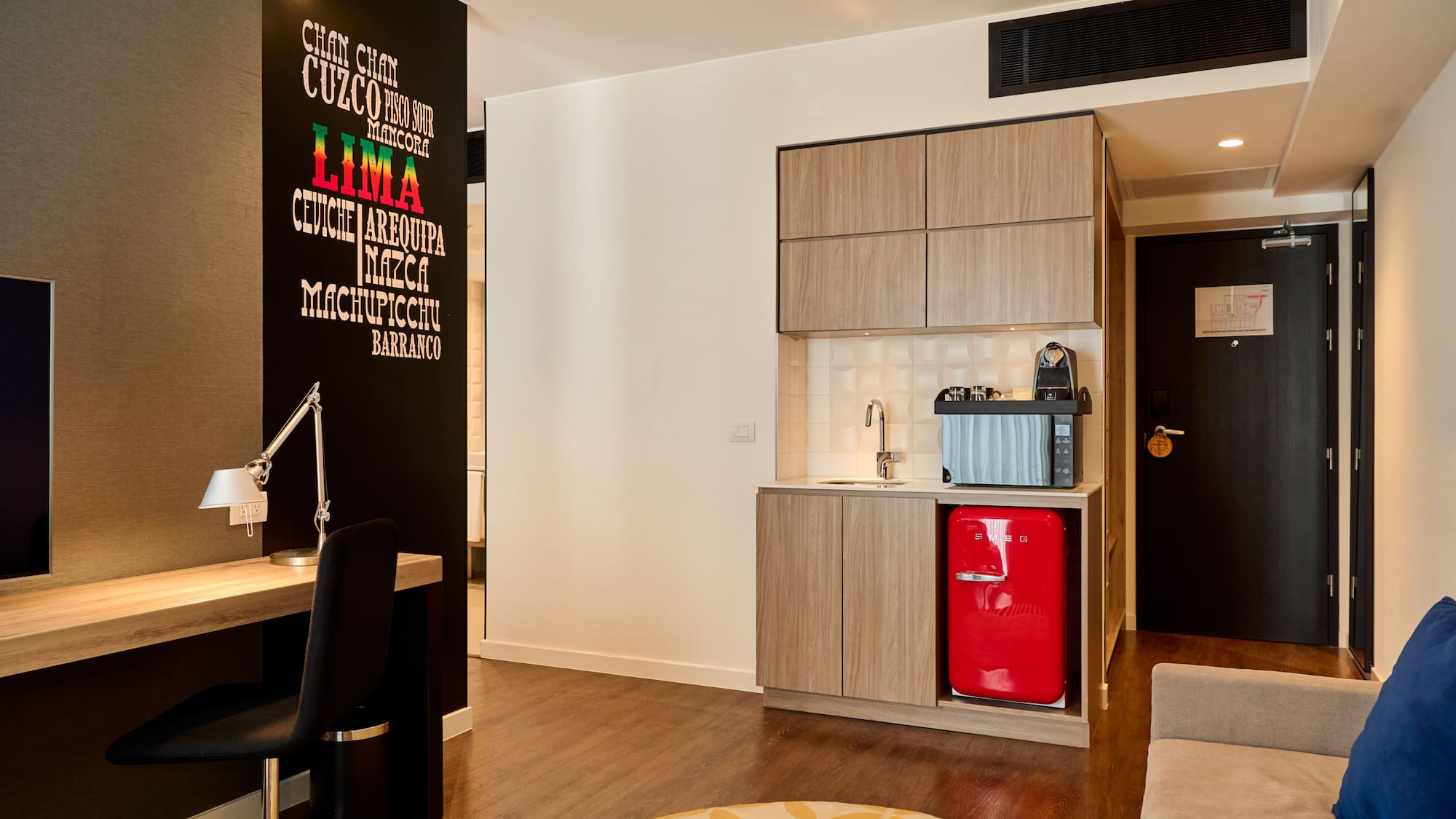 a room with a red refrigerator and a desk