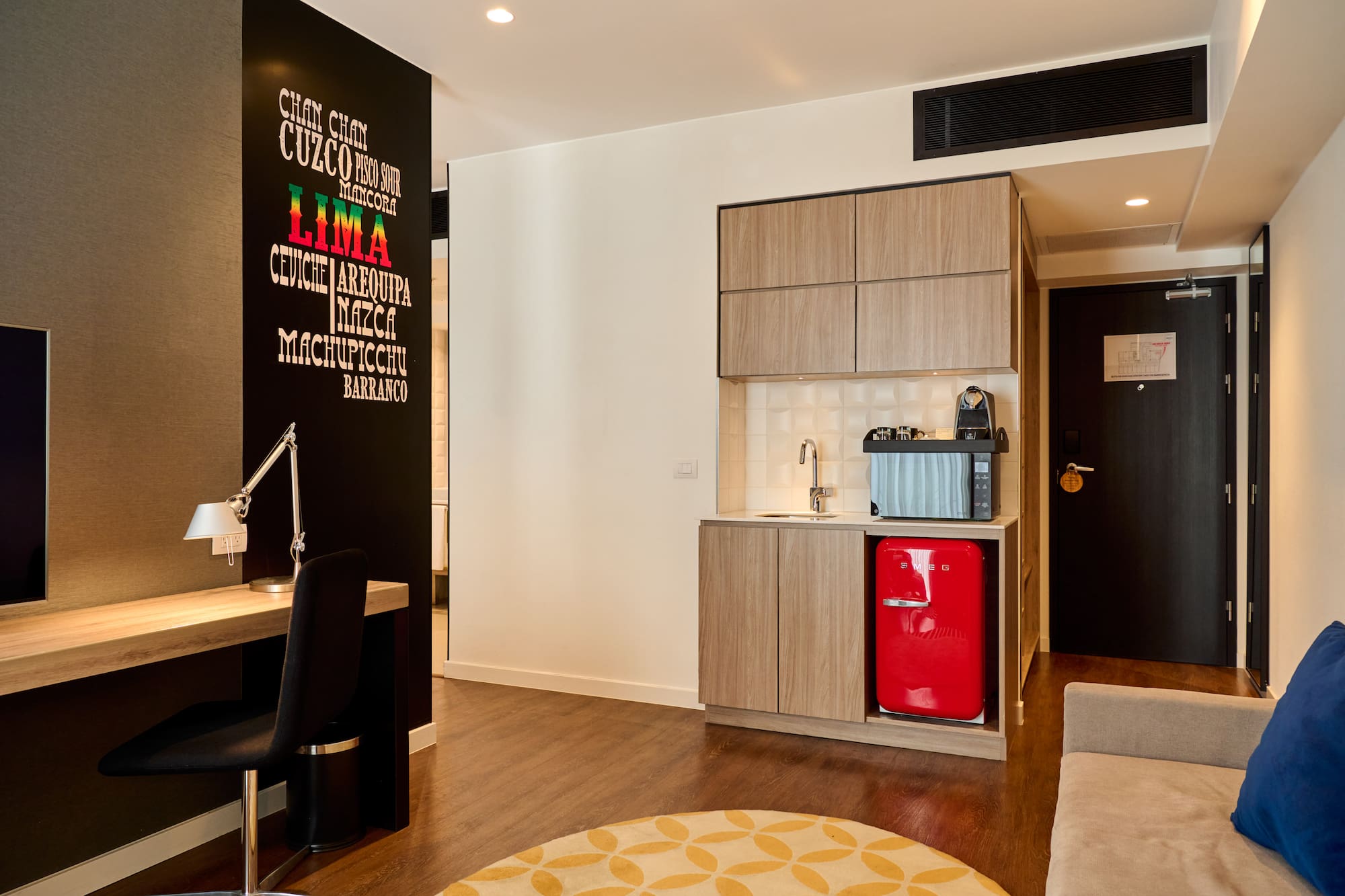 a room with a red refrigerator and a desk