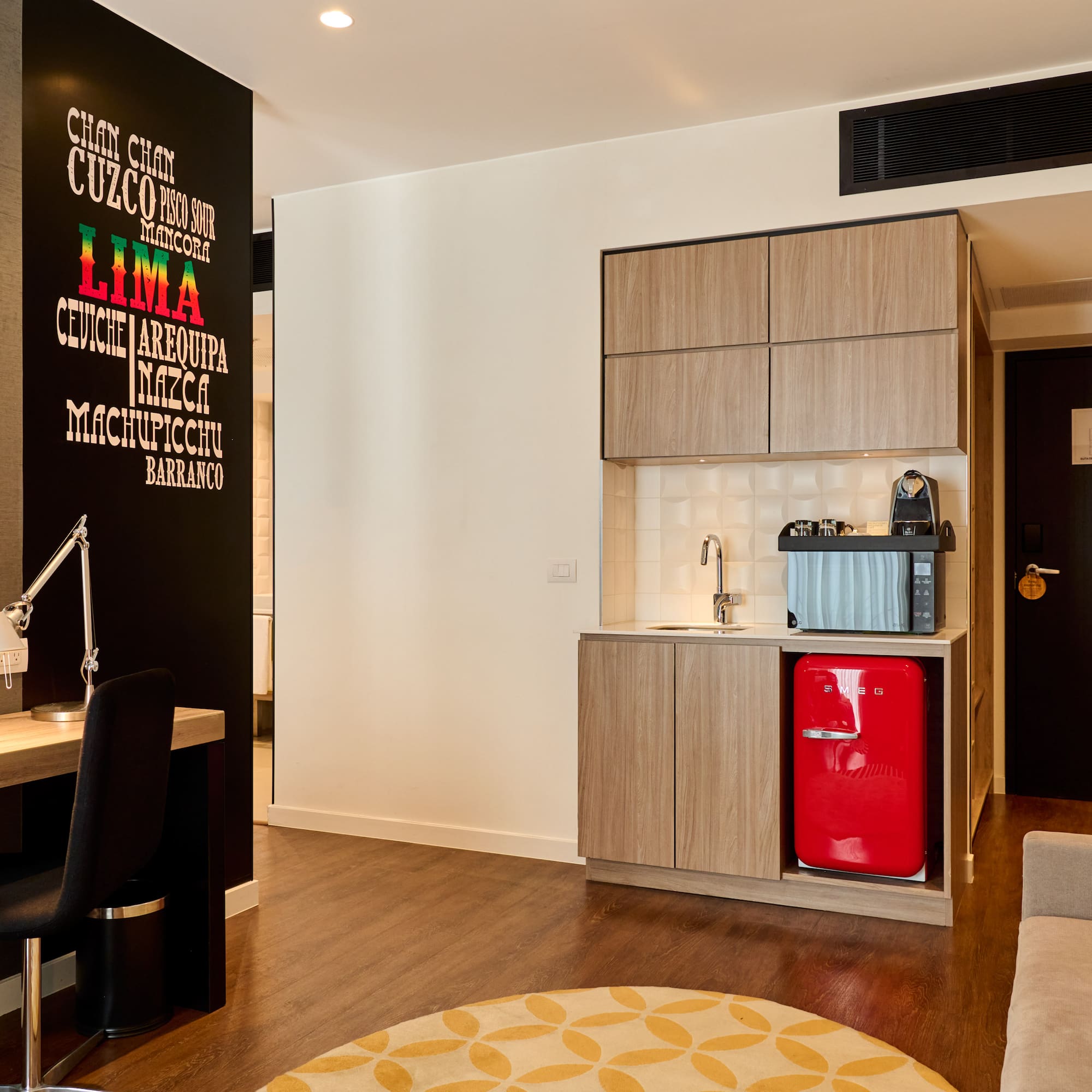 a room with a red refrigerator and a desk