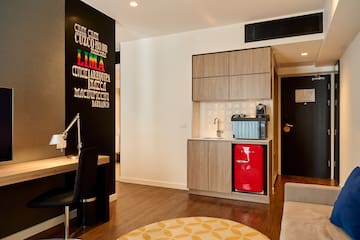 a room with a red refrigerator and a desk