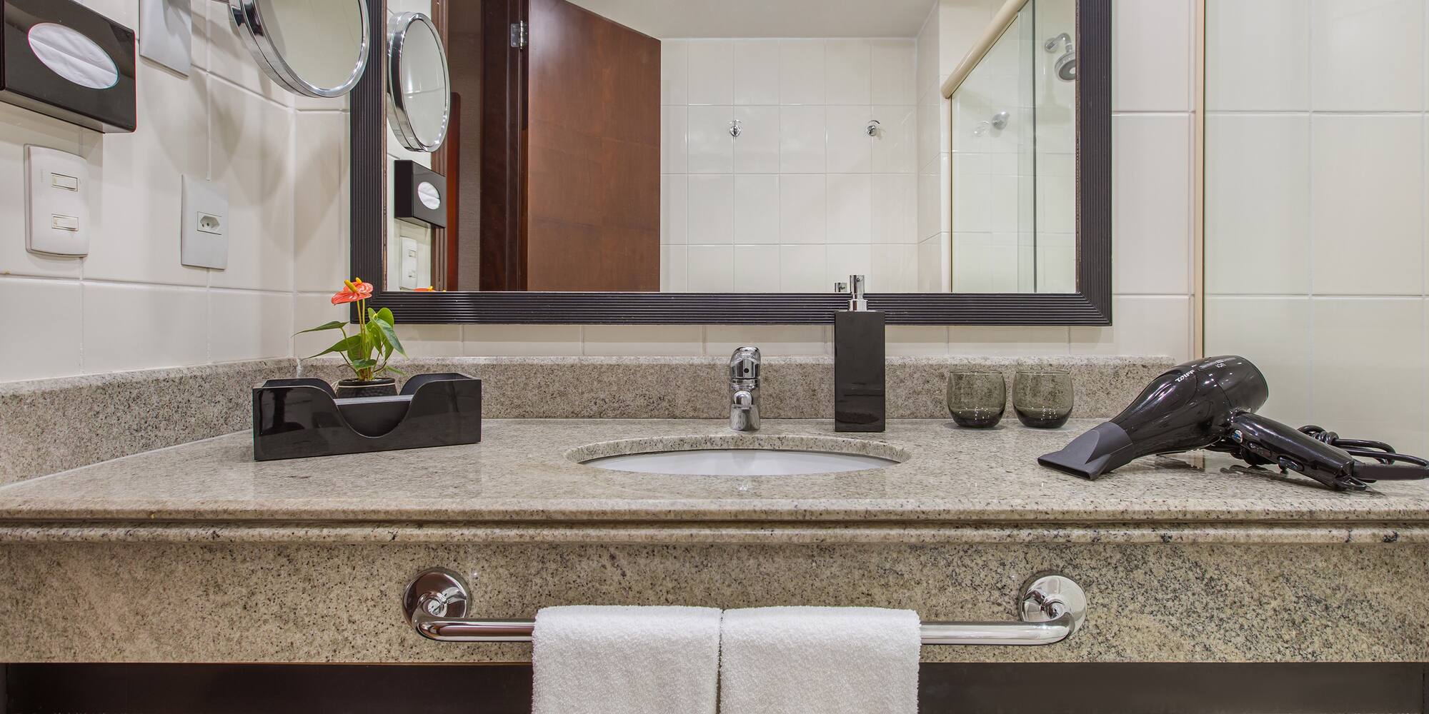 a bathroom sink with a mirror and a blow dryer