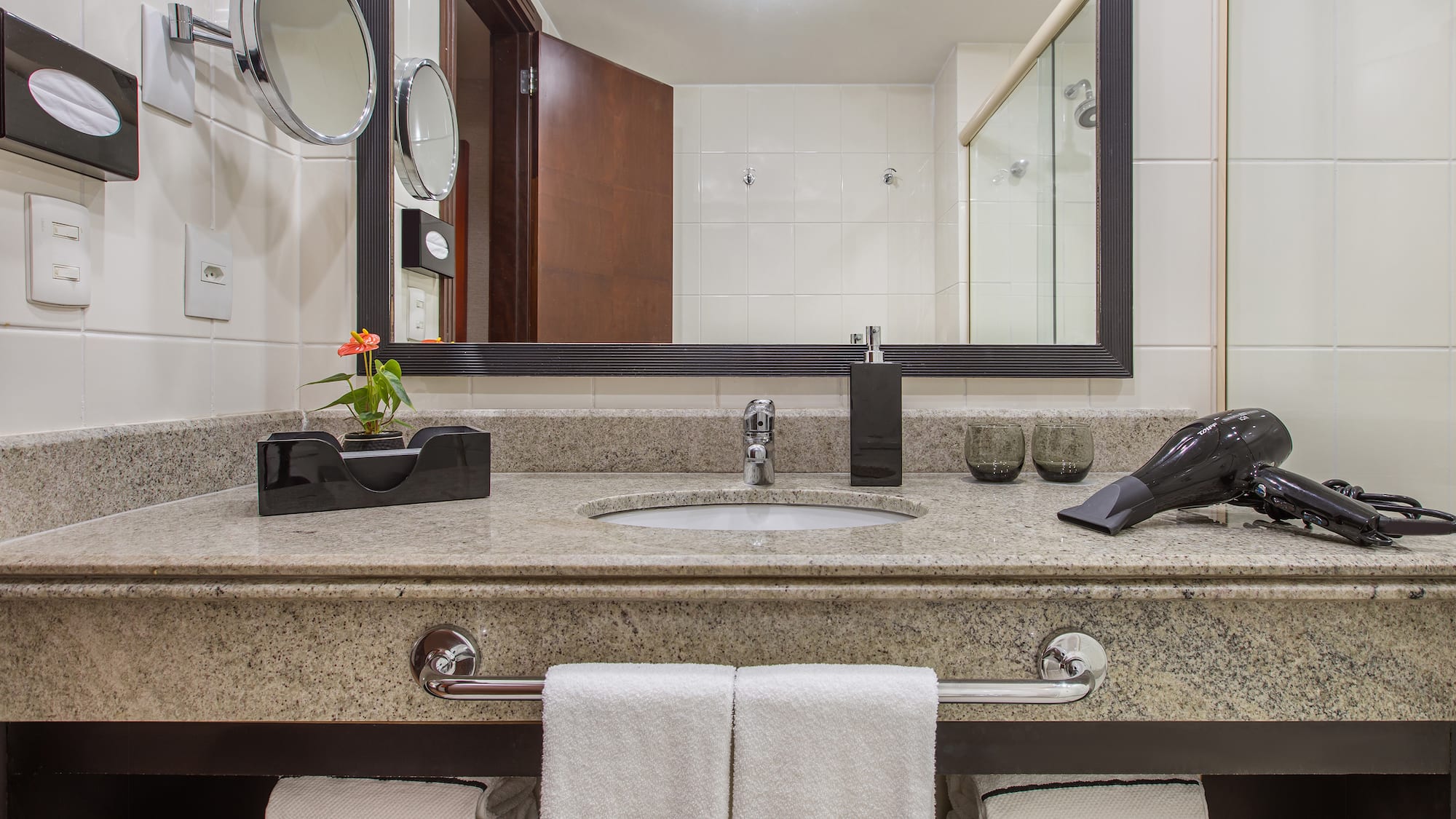 a bathroom sink with a mirror and a blow dryer