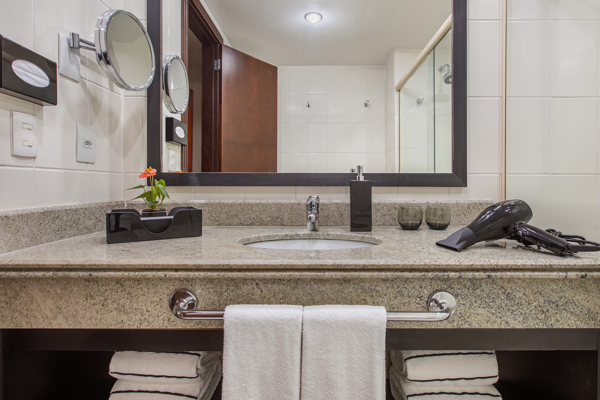 a bathroom sink with a mirror and a blow dryer