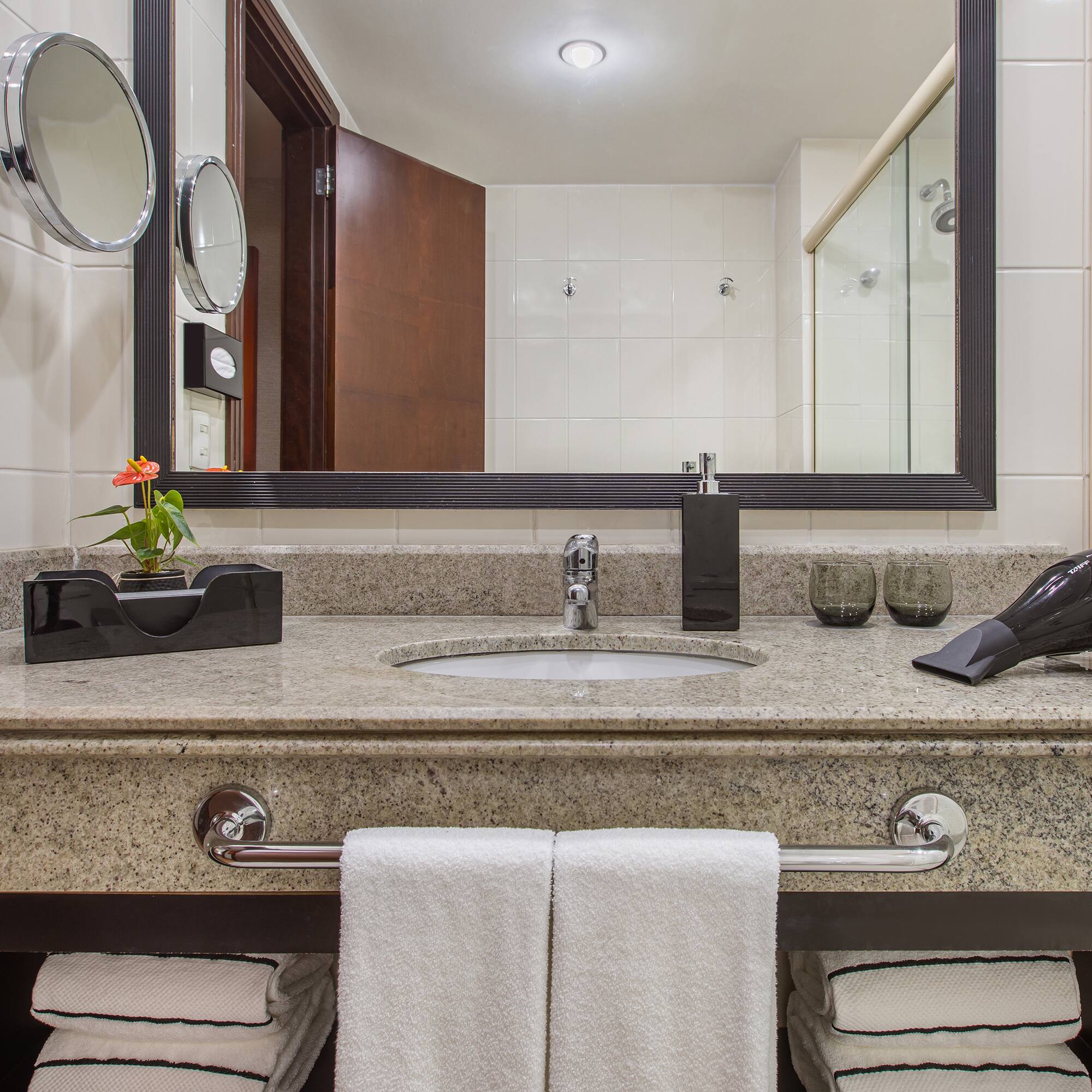 a bathroom sink with a mirror and a blow dryer