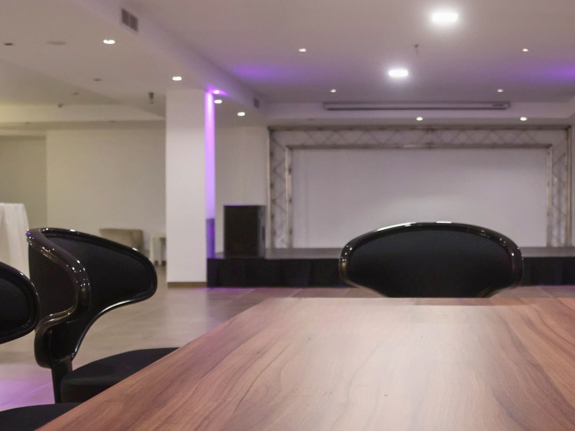 a table with chairs in a room with purple lights