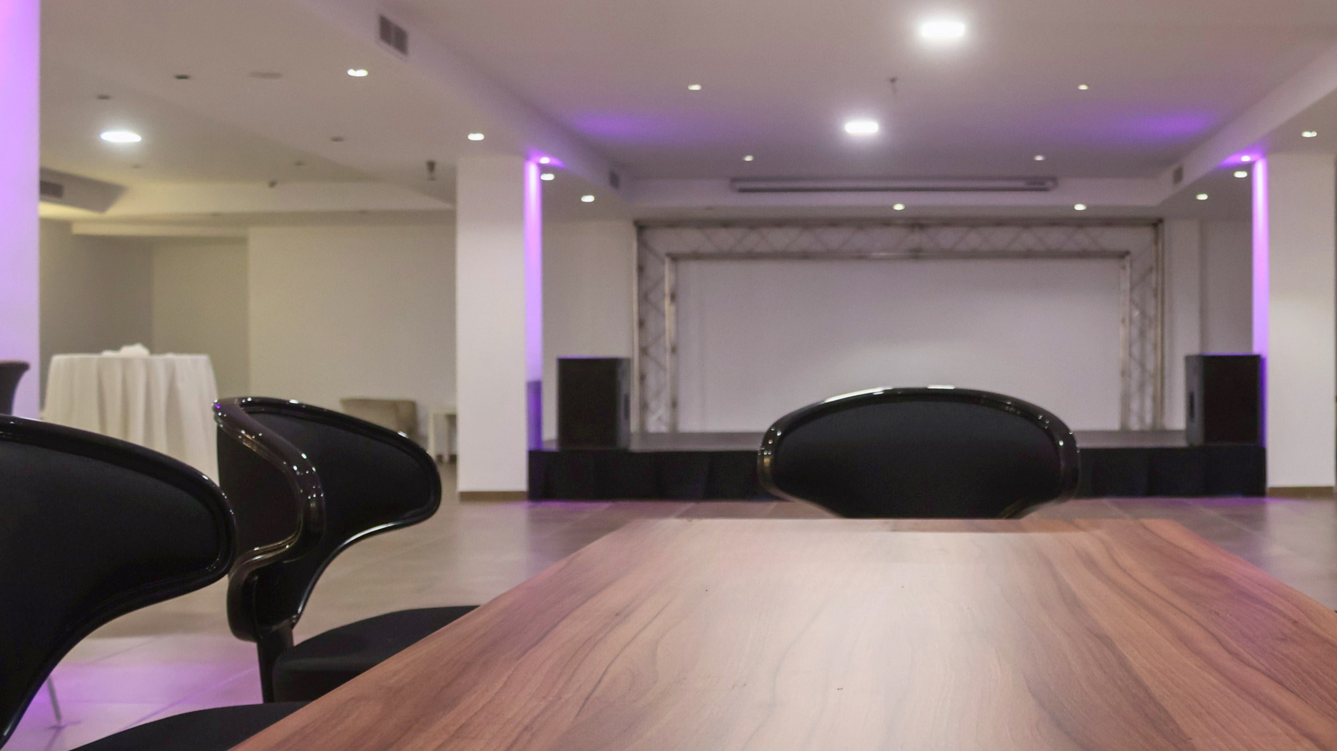 a table with chairs in a room with purple lights