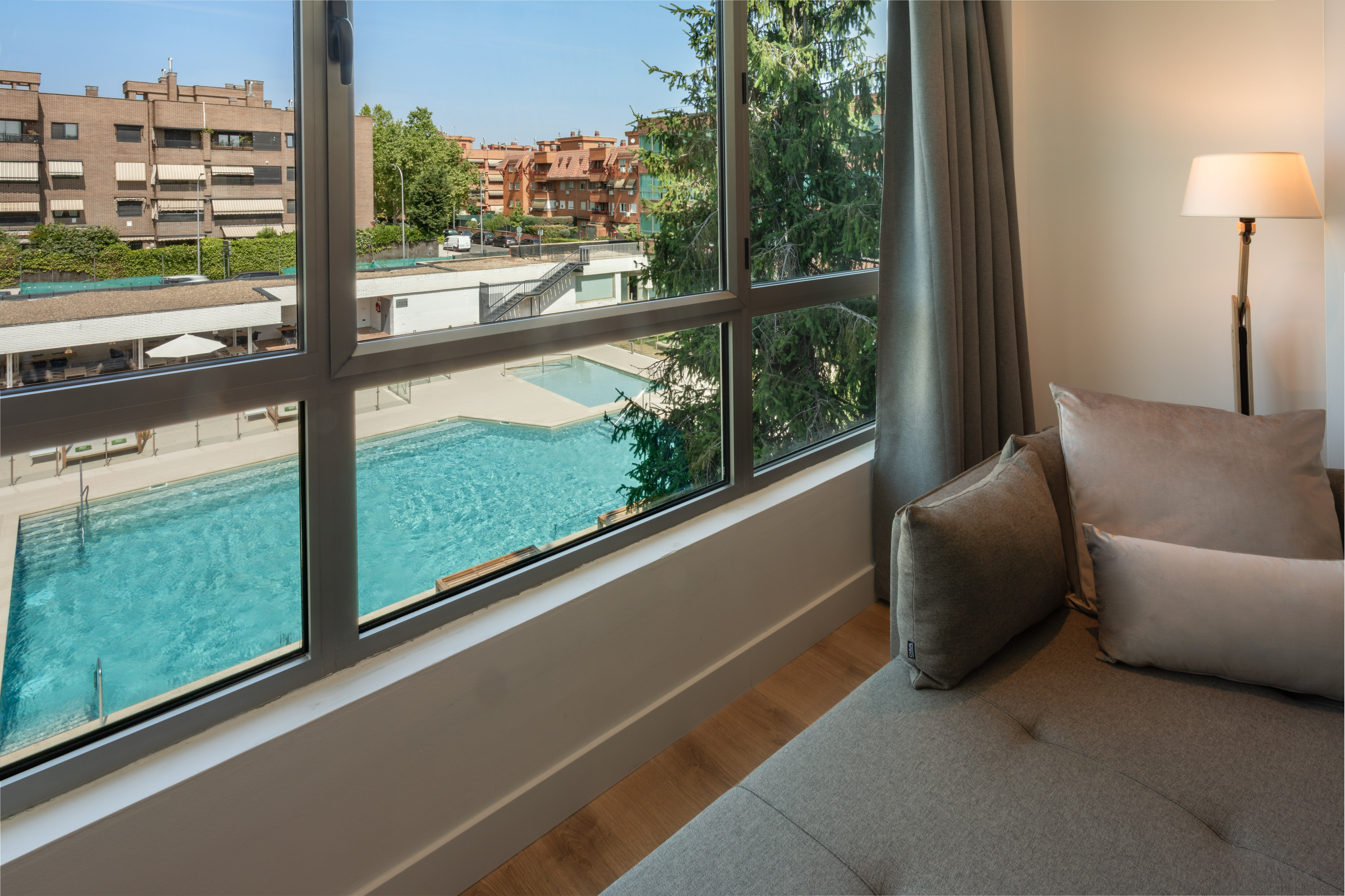 Modern room with city view, two swimming pools, and a comfortable lounge area.