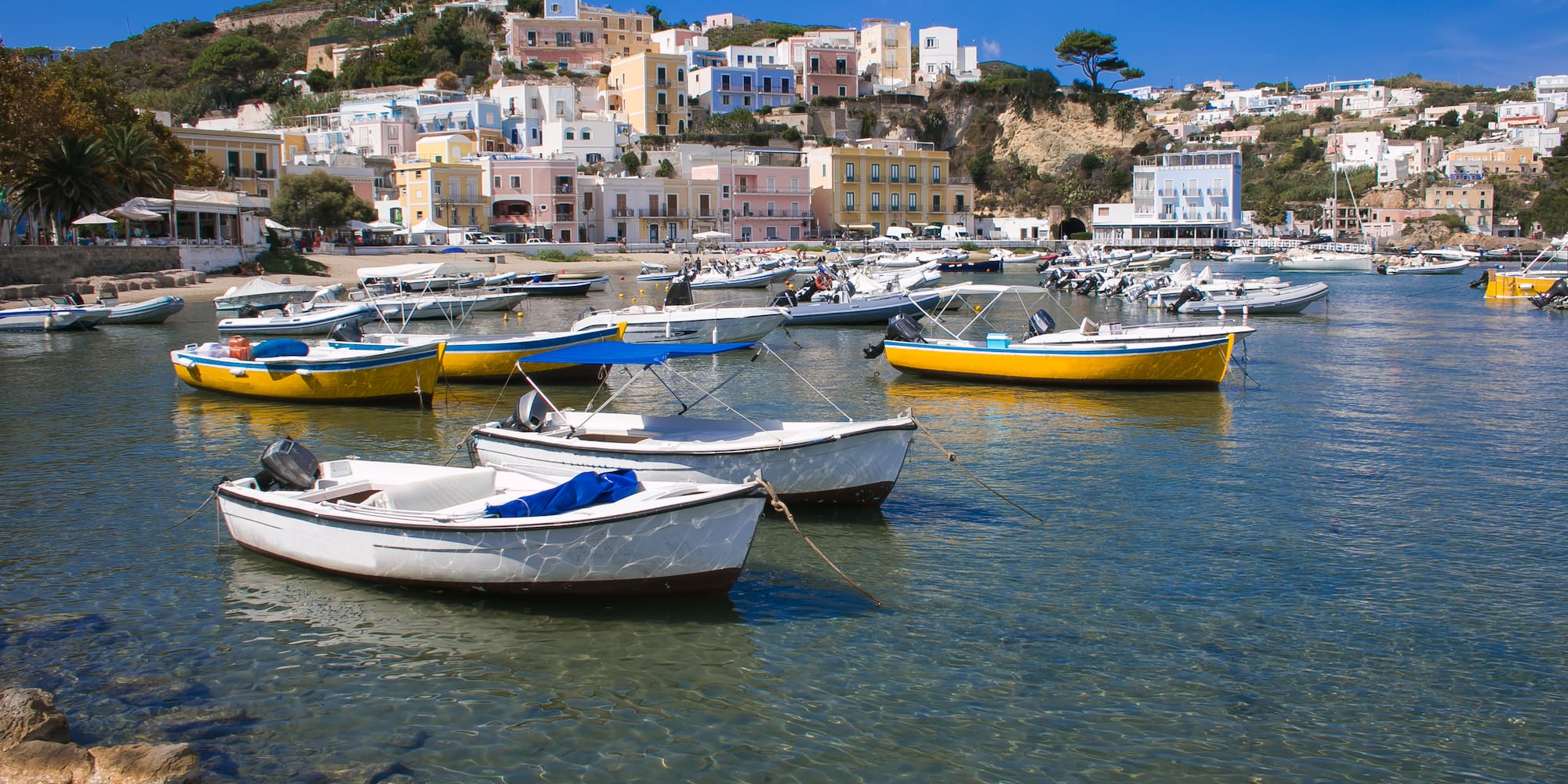 boats in a body of water with buildings in the background