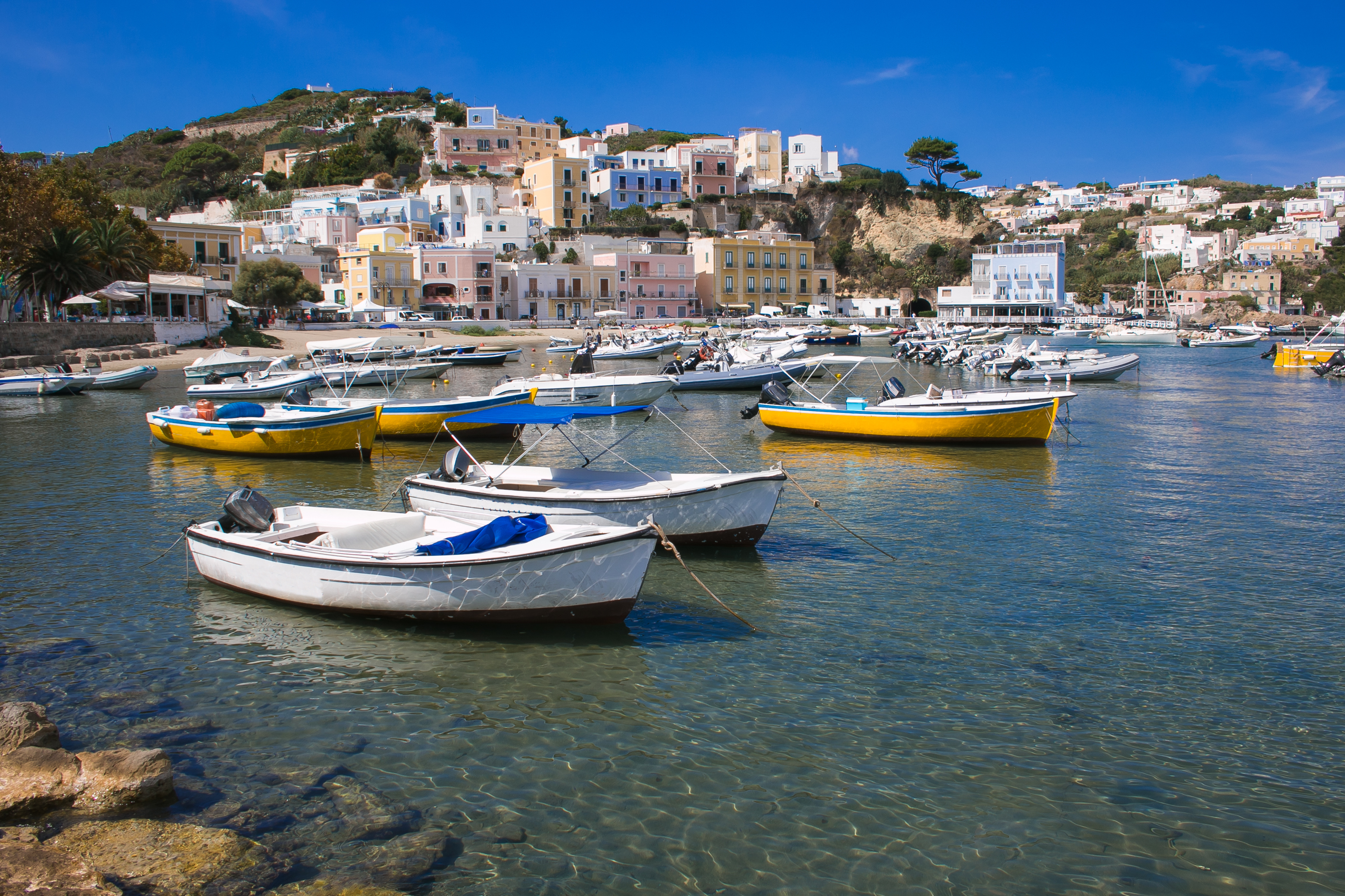 boats in a body of water with buildings in the background