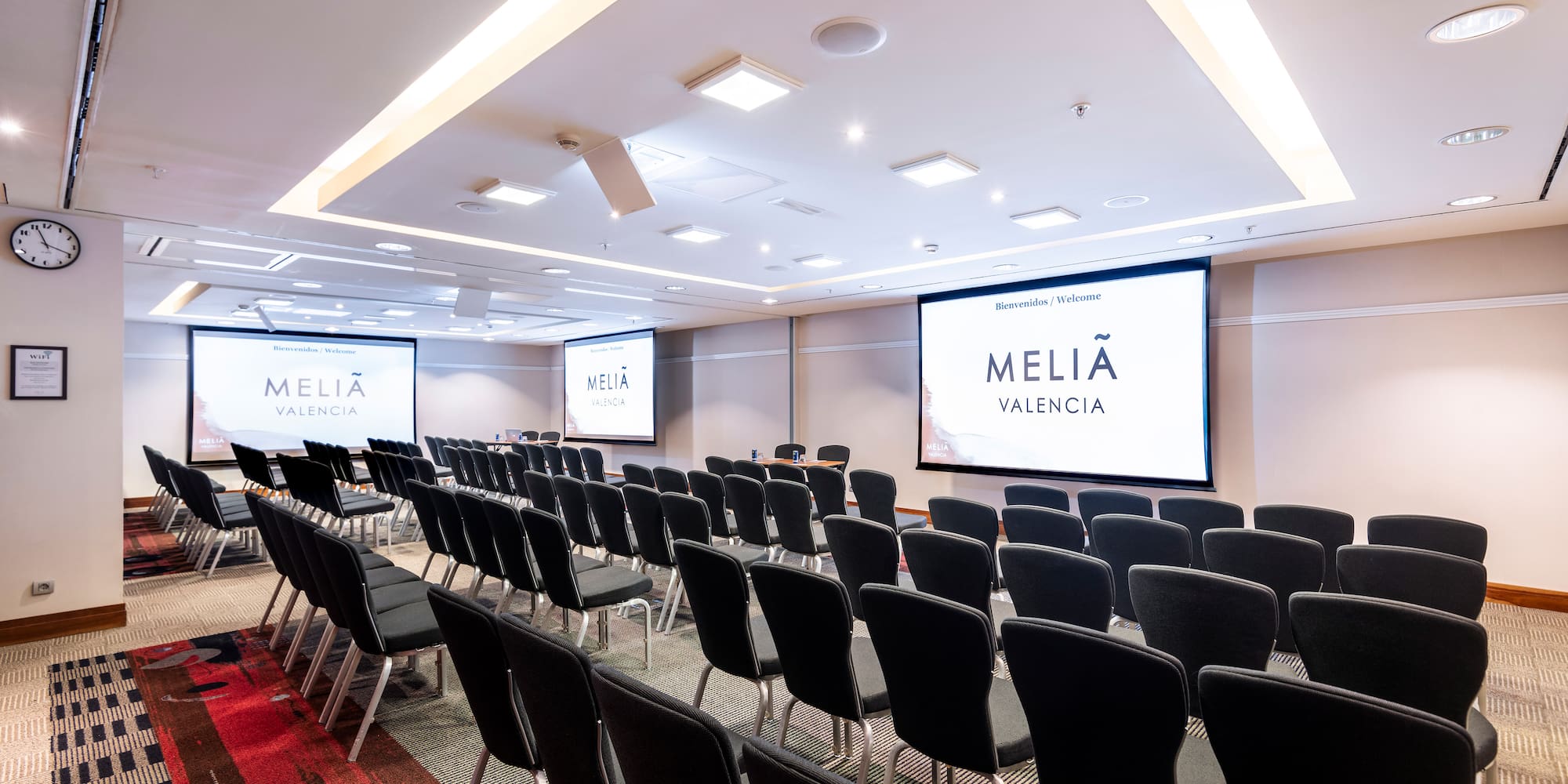 a room with chairs and projector screens