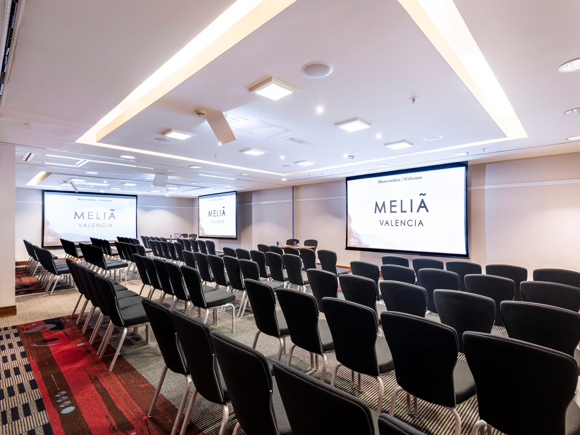 a room with chairs and projector screens