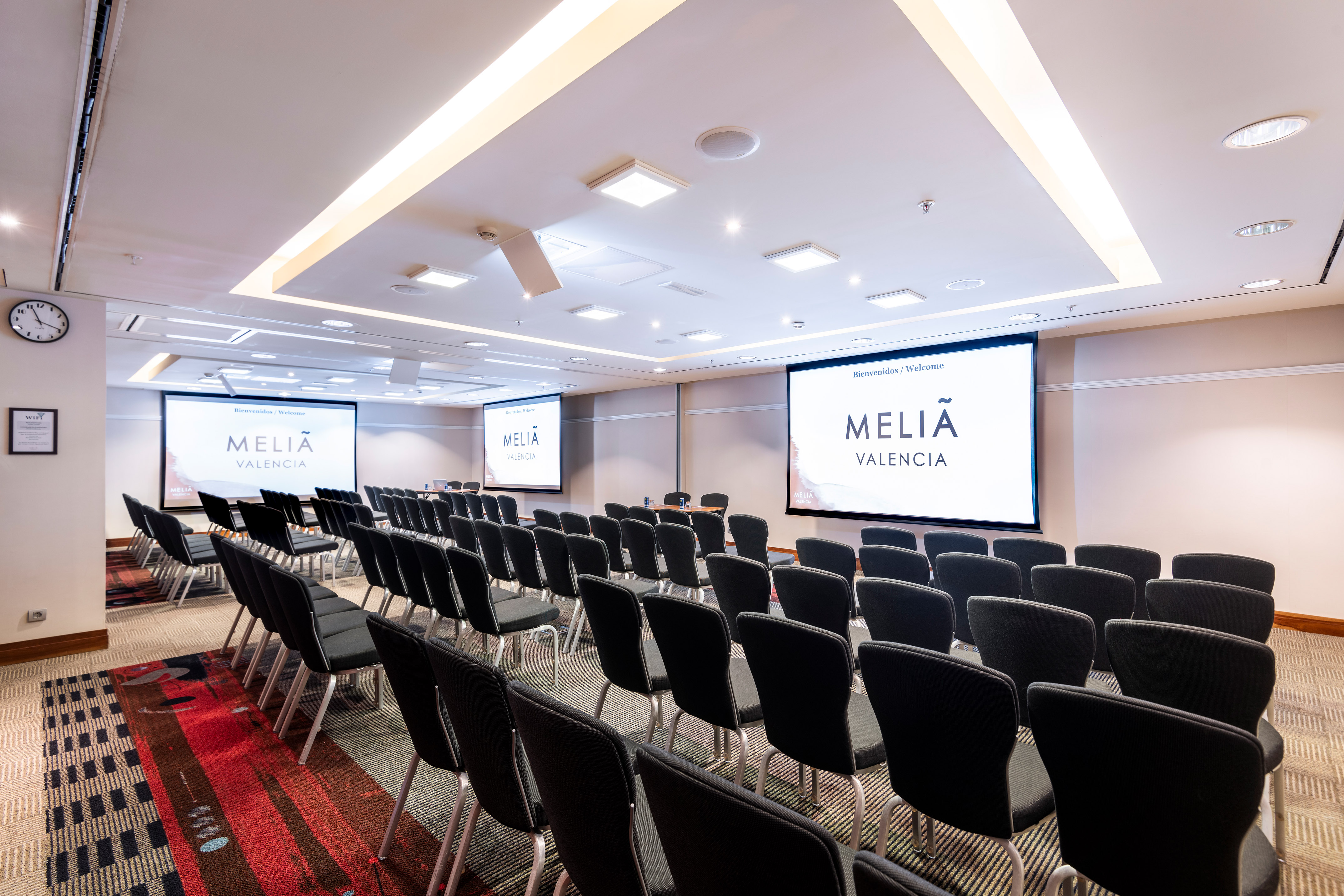 a room with chairs and projector screens