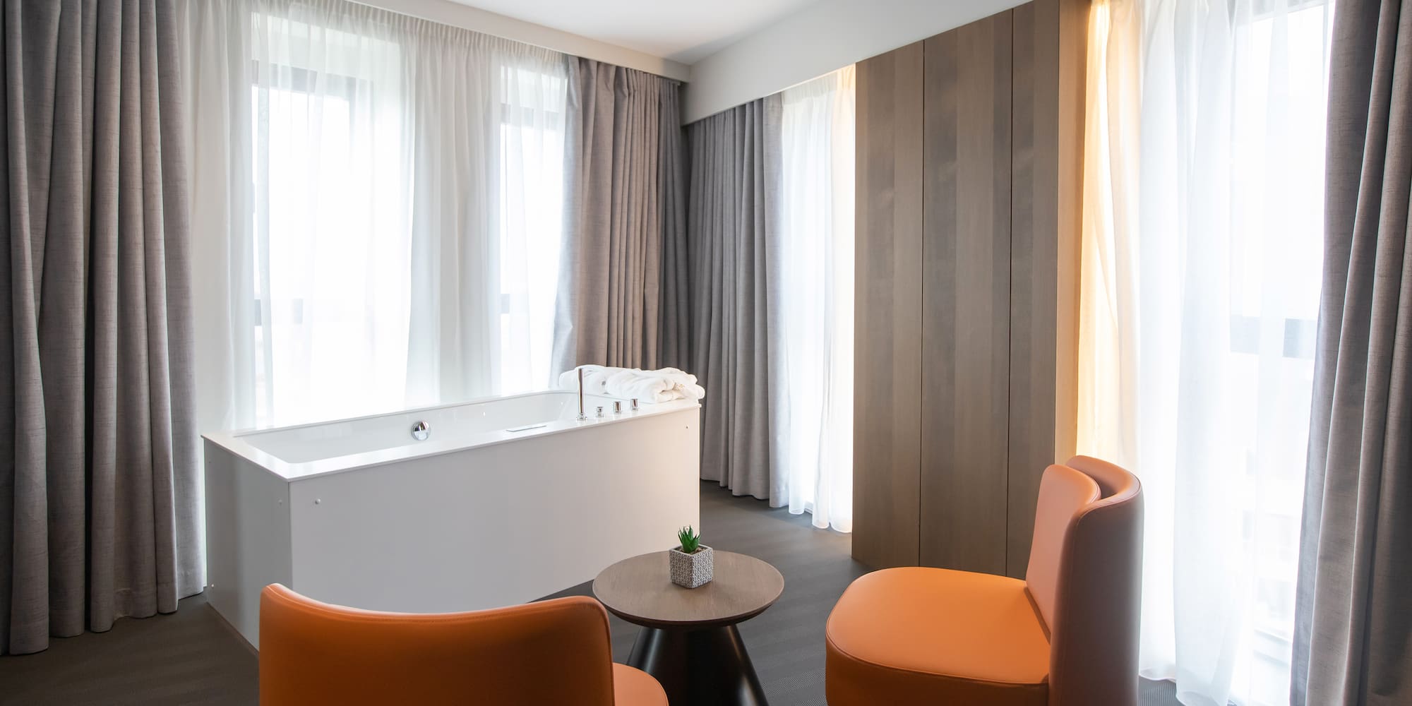 a room with a tub and chairs