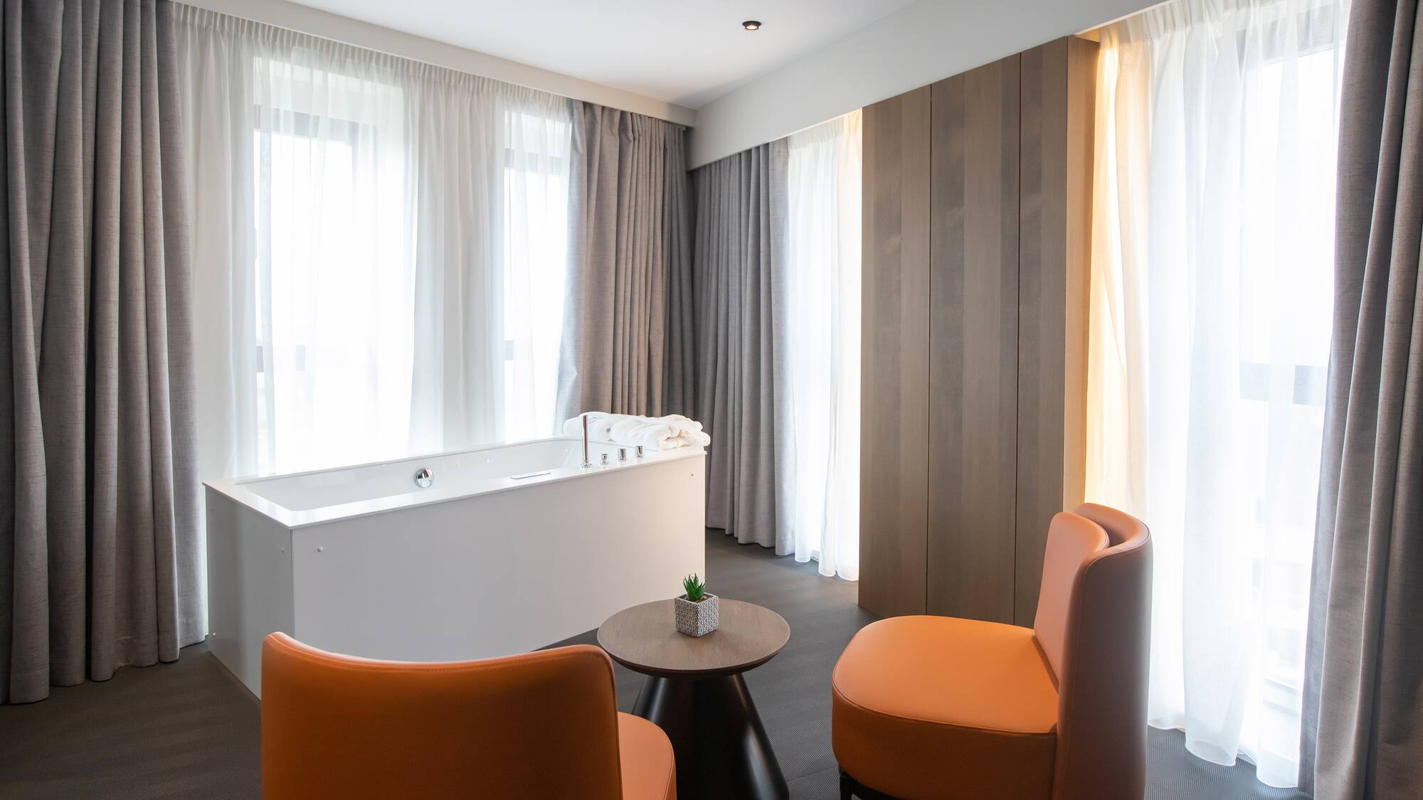 a room with a tub and chairs