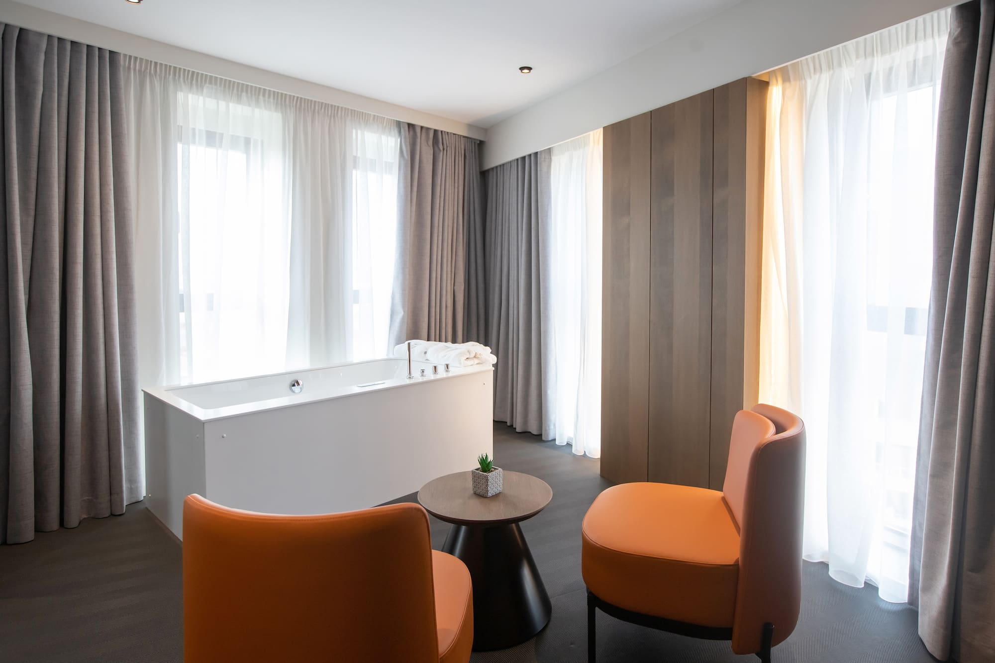 a room with a tub and chairs