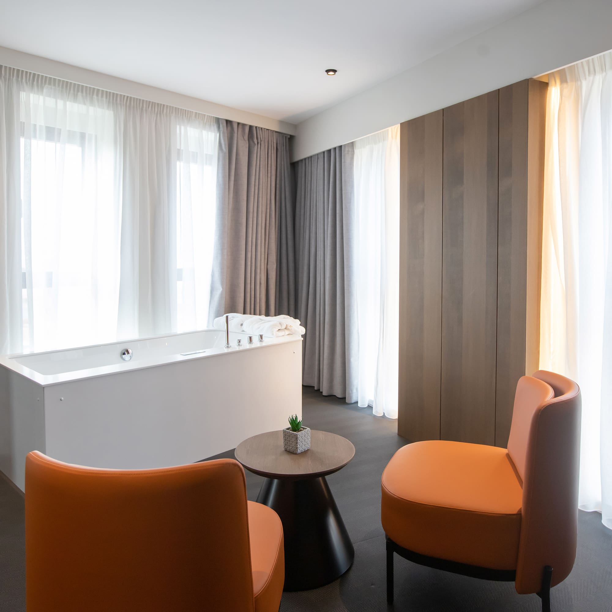 a room with a tub and chairs