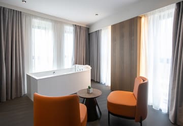 a room with a tub and chairs
