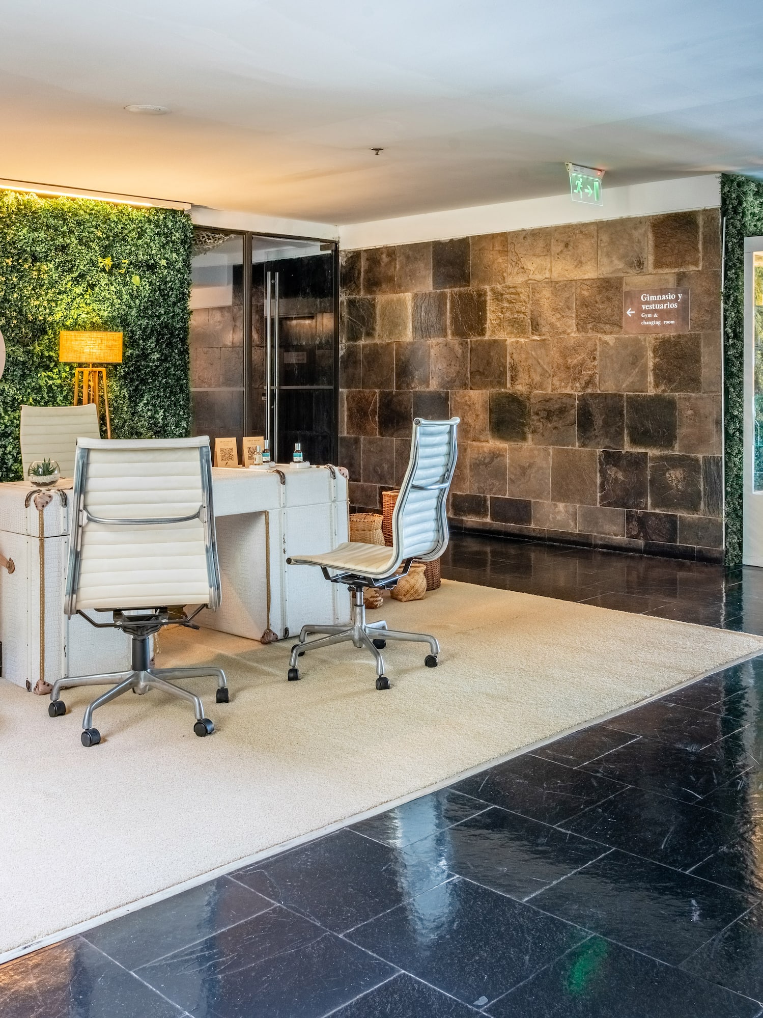 a room with chairs and a wall of plants