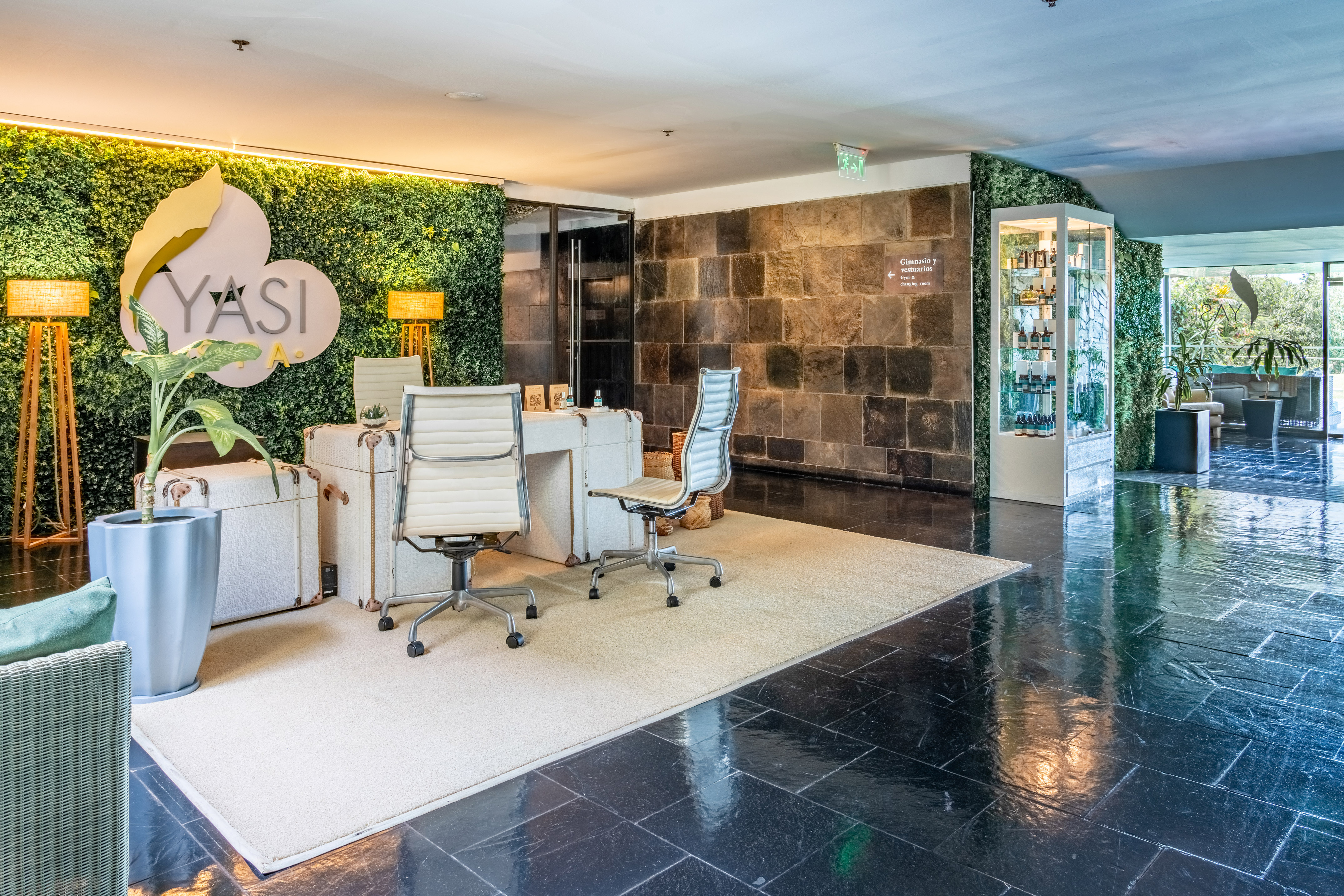 a room with chairs and a wall of plants