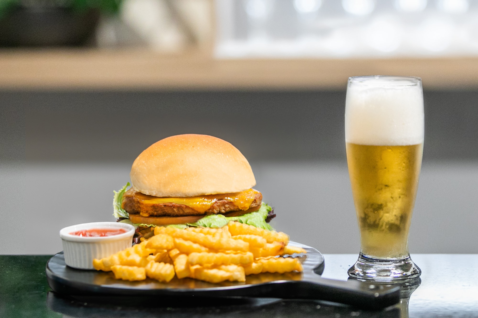 Hamburguesa con queso, papas fritas, kétchup y cerveza rubia.