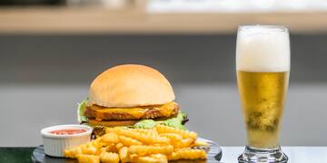 a burger and fries on a plate next to a glass of beer