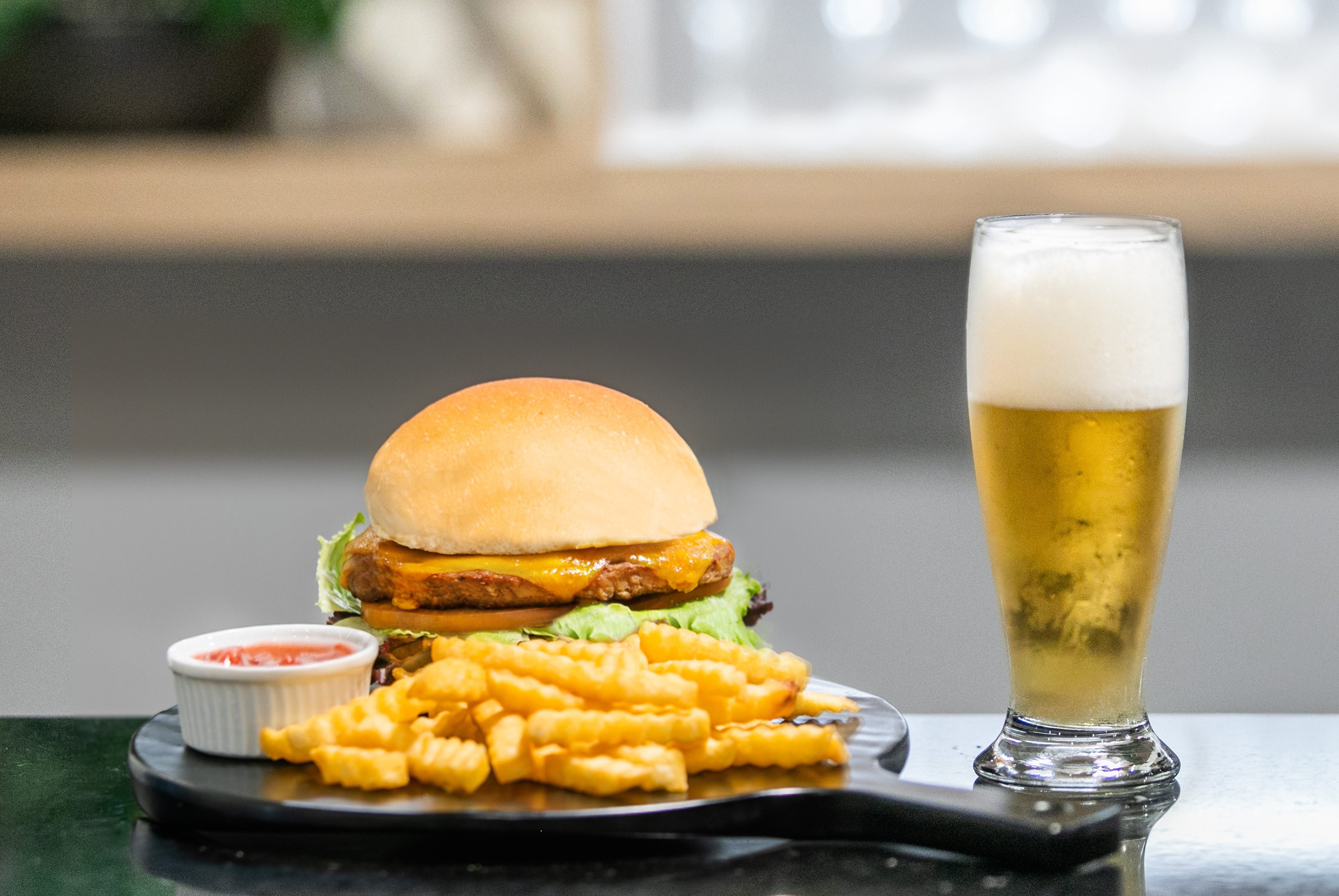 Hamburguesa con queso, papas fritas, kétchup y cerveza rubia.