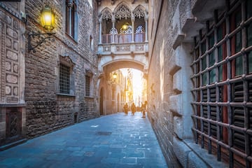 a stone alley between buildings with people walking