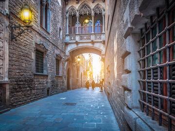 a stone alley between buildings with people walking