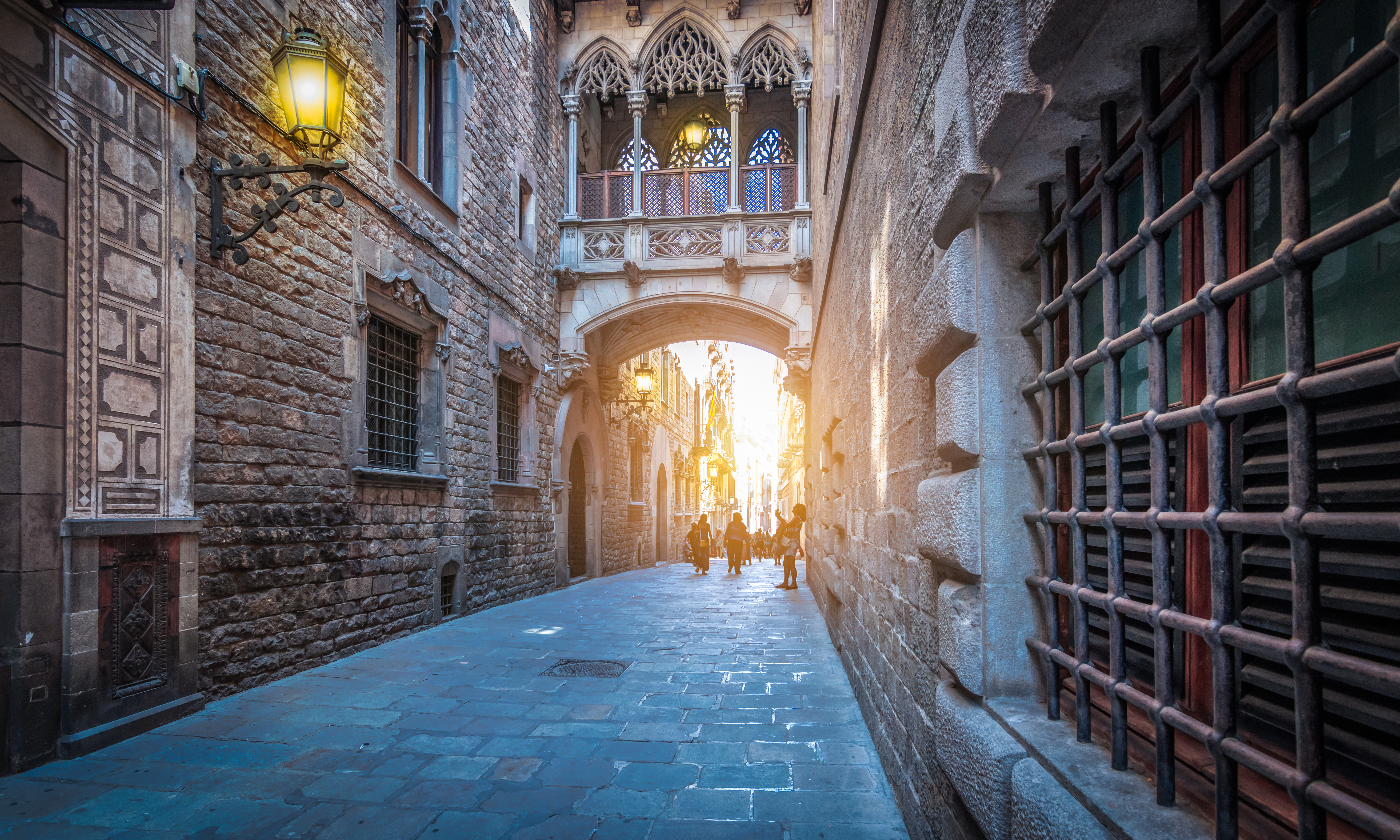 Pont del Bisbe en el Barrio Gótico de Barcelona, calle gótica con luz solar.