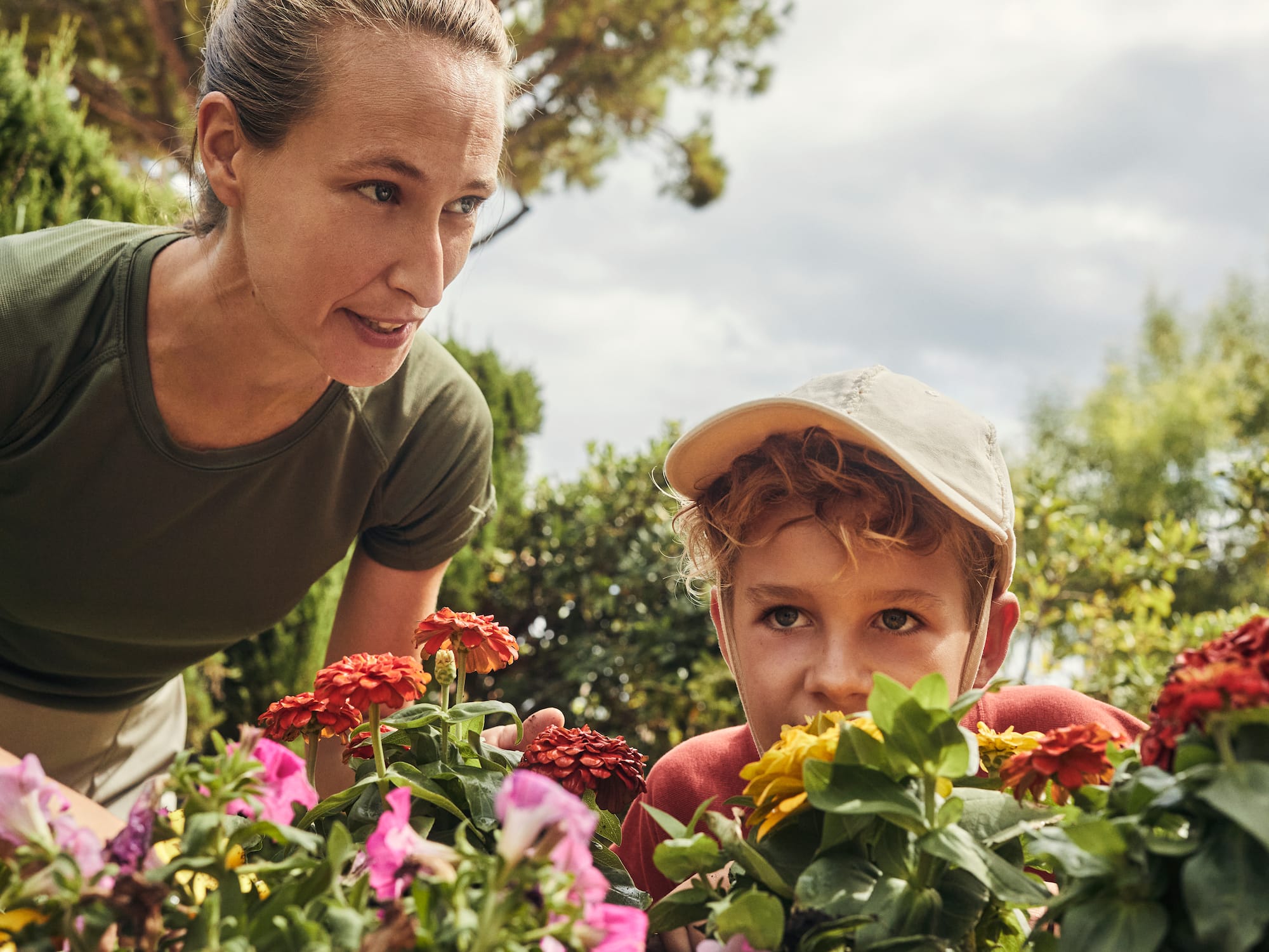 a woman and a boy looking at flowers