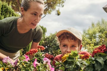 a woman and a boy looking at flowers