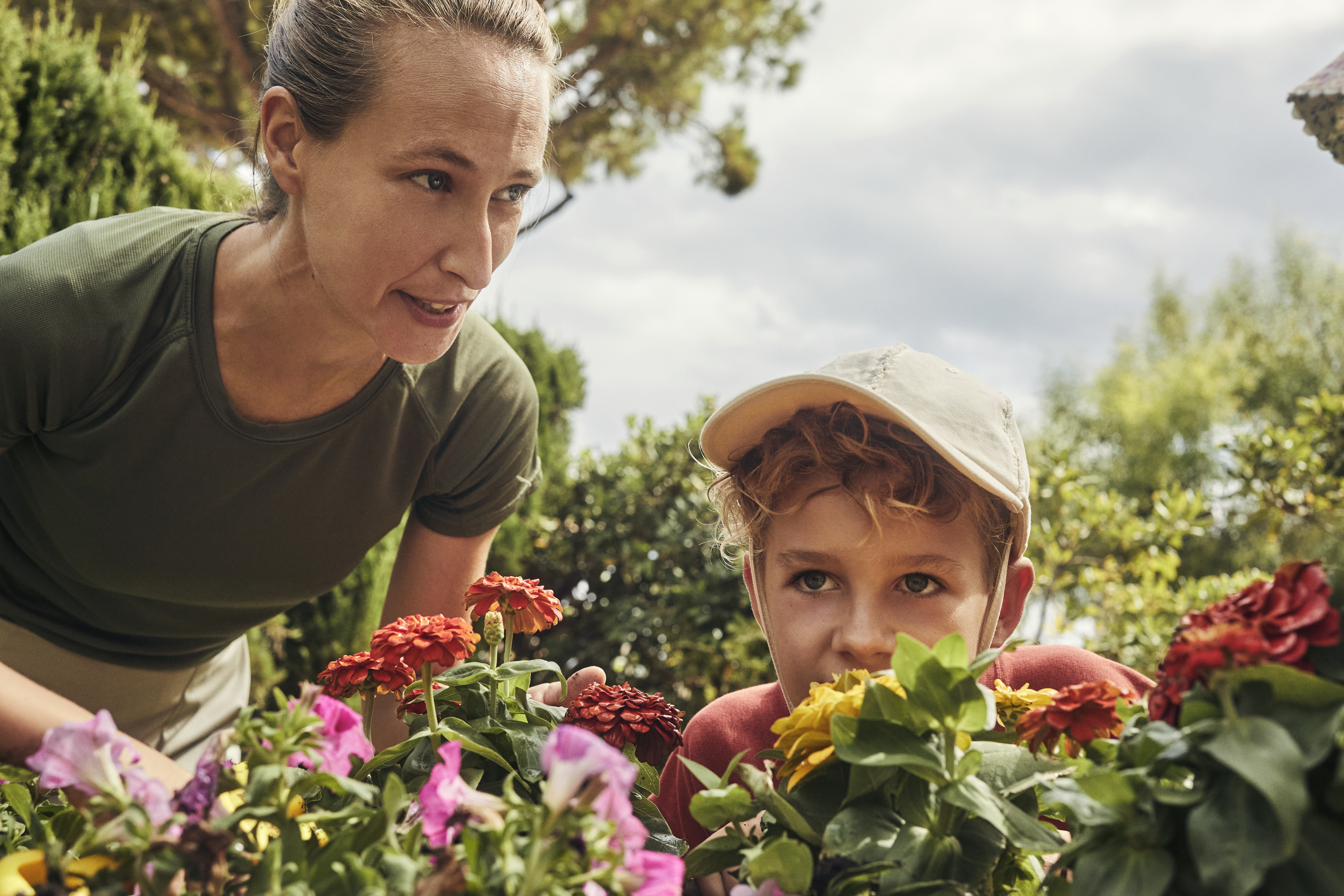 a woman and a boy looking at flowers