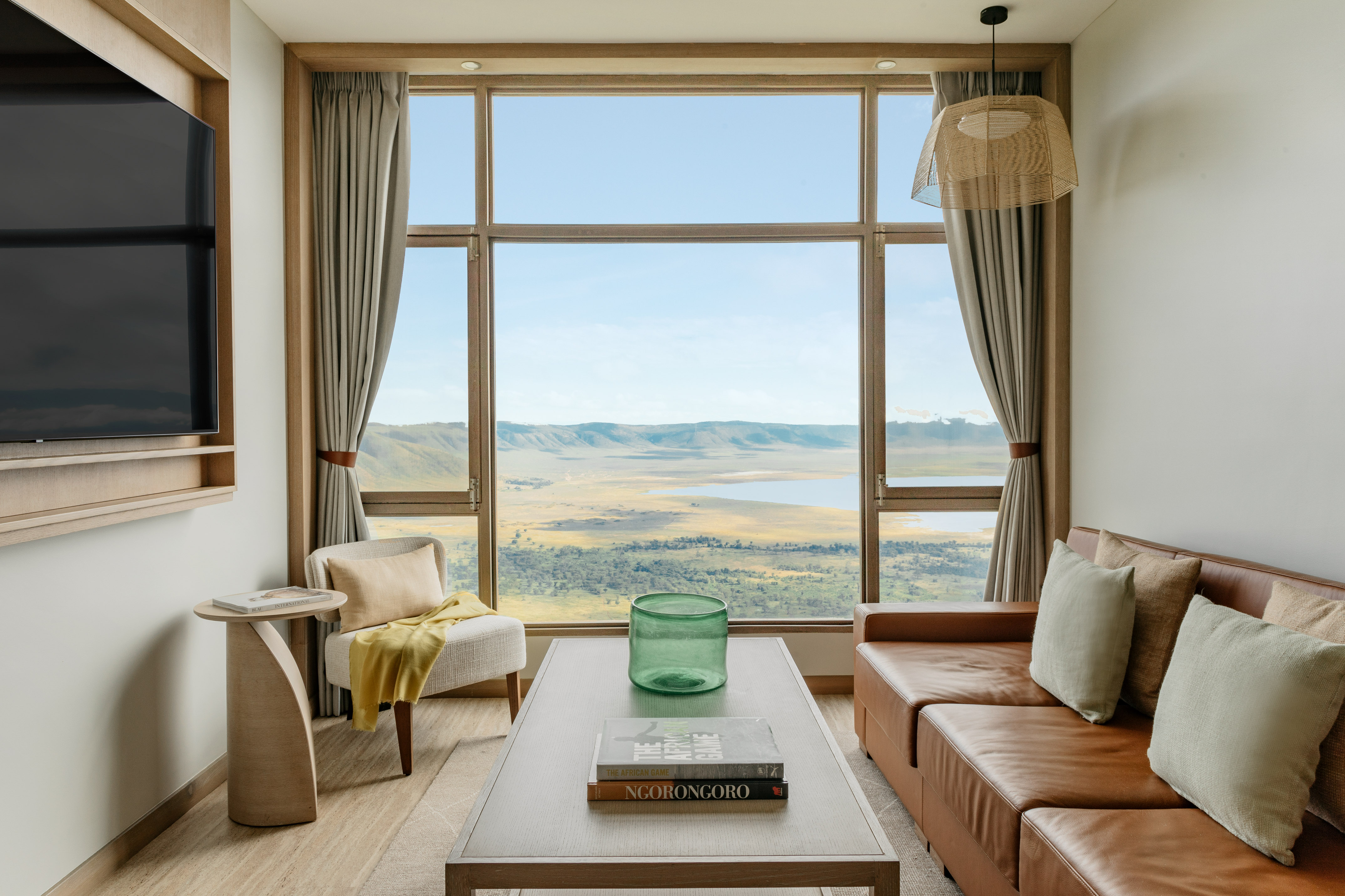Panoramic Ngorongoro Crater view from a luxury suite living room.