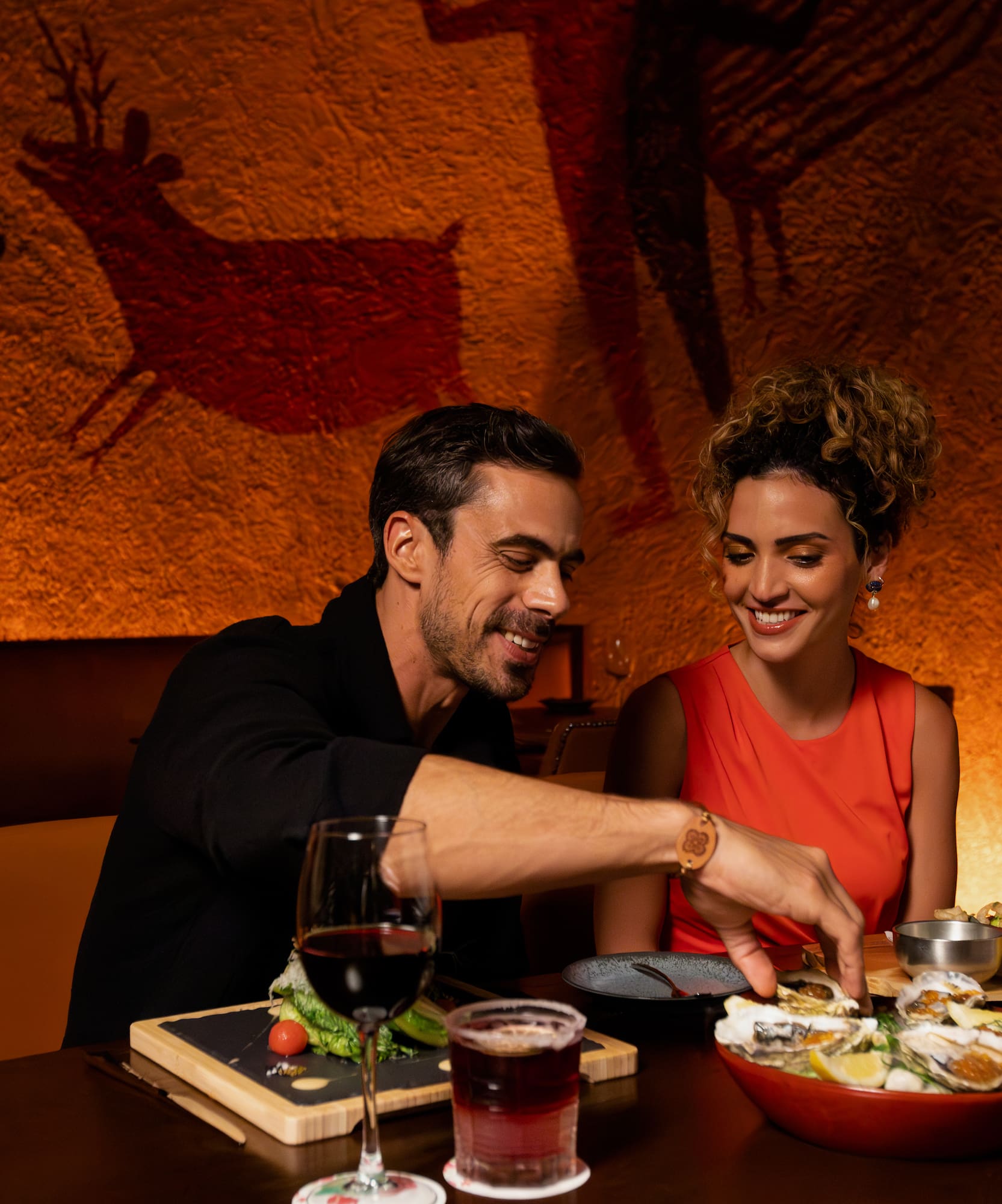 a man and woman sitting at a table with food