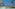 Outdoor pool with sun loungers, palm trees, overlooking a marina.