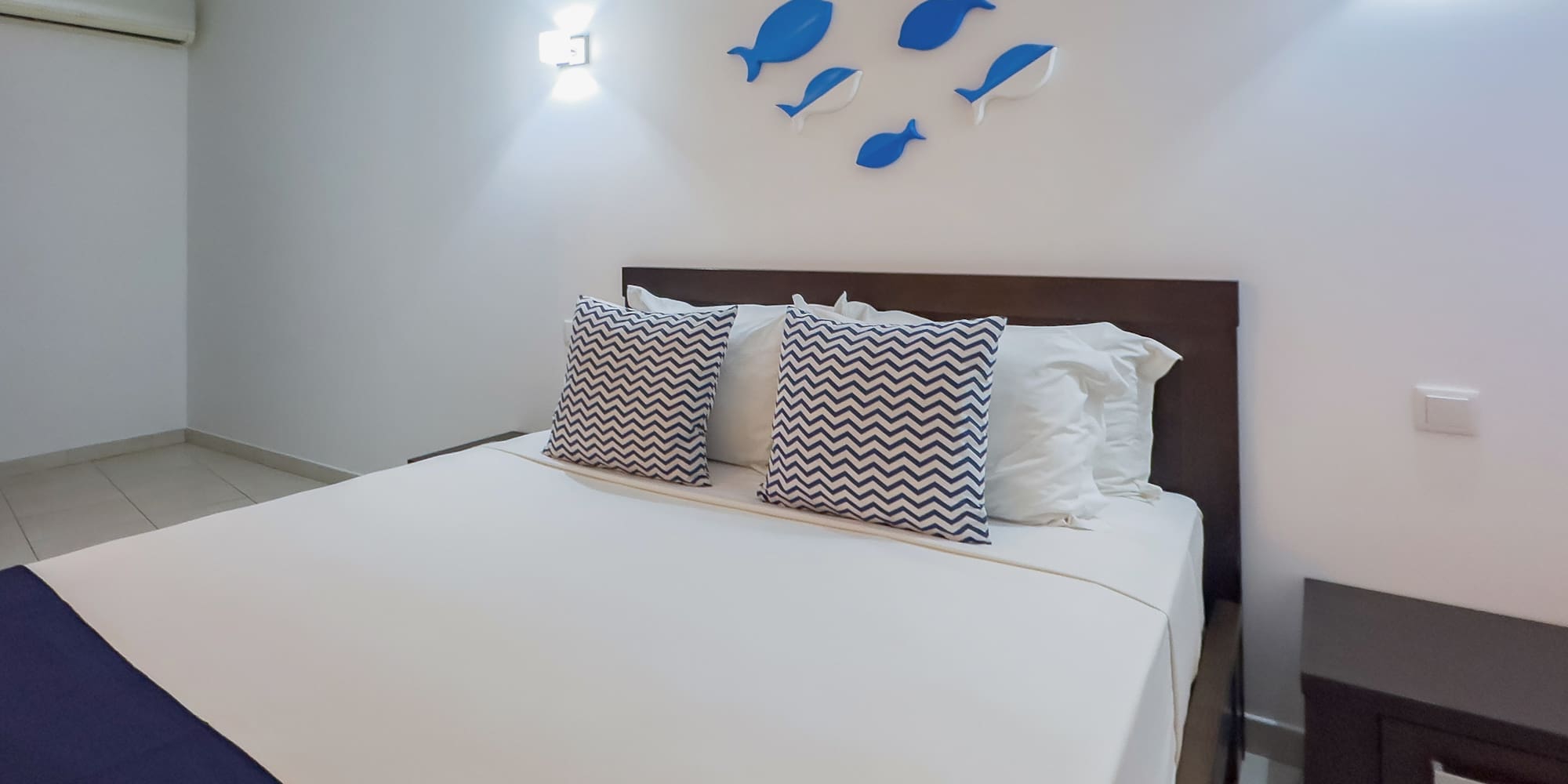 a bed with pillows and a fish on the wall