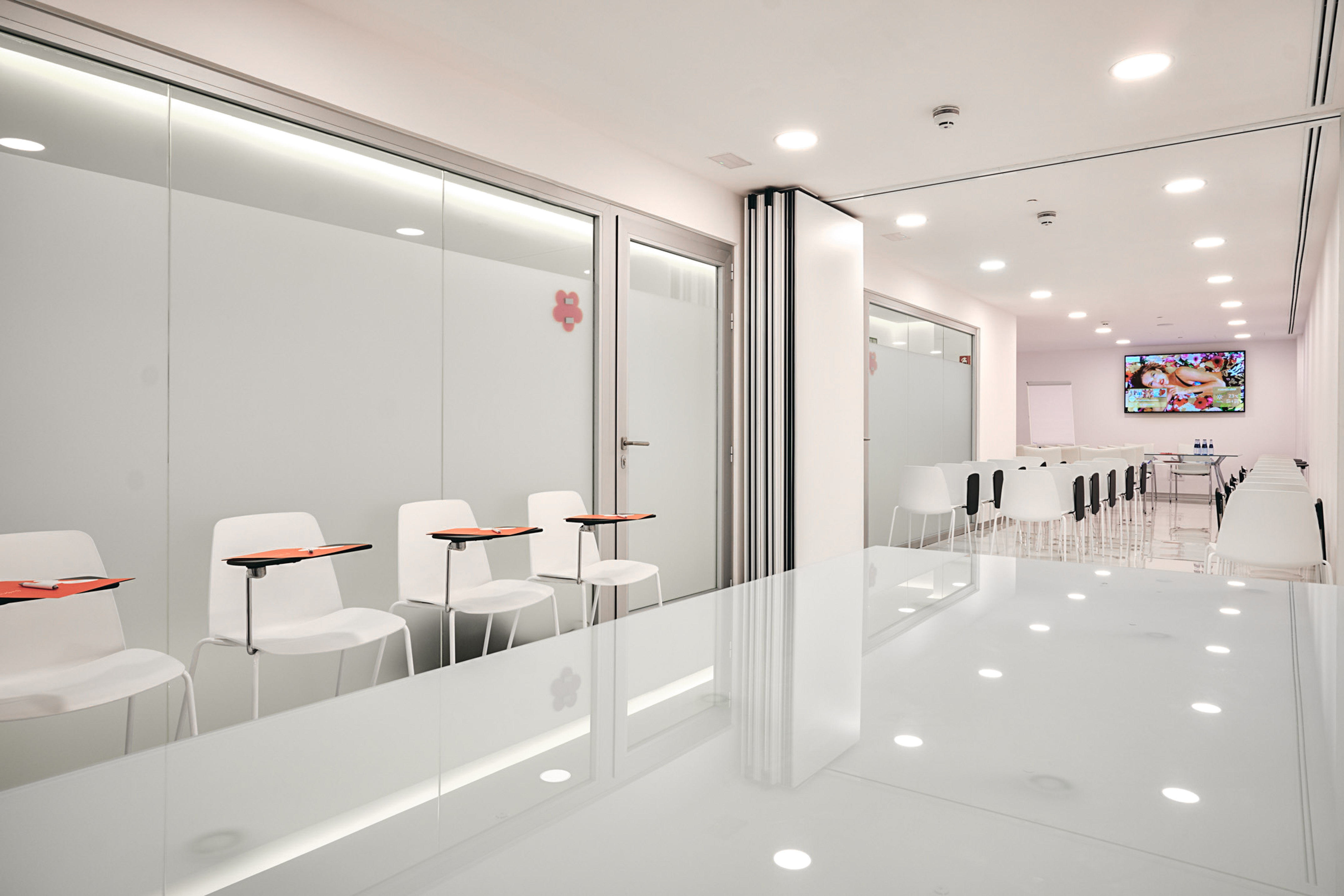Bright modern waiting area and training room with white chairs.