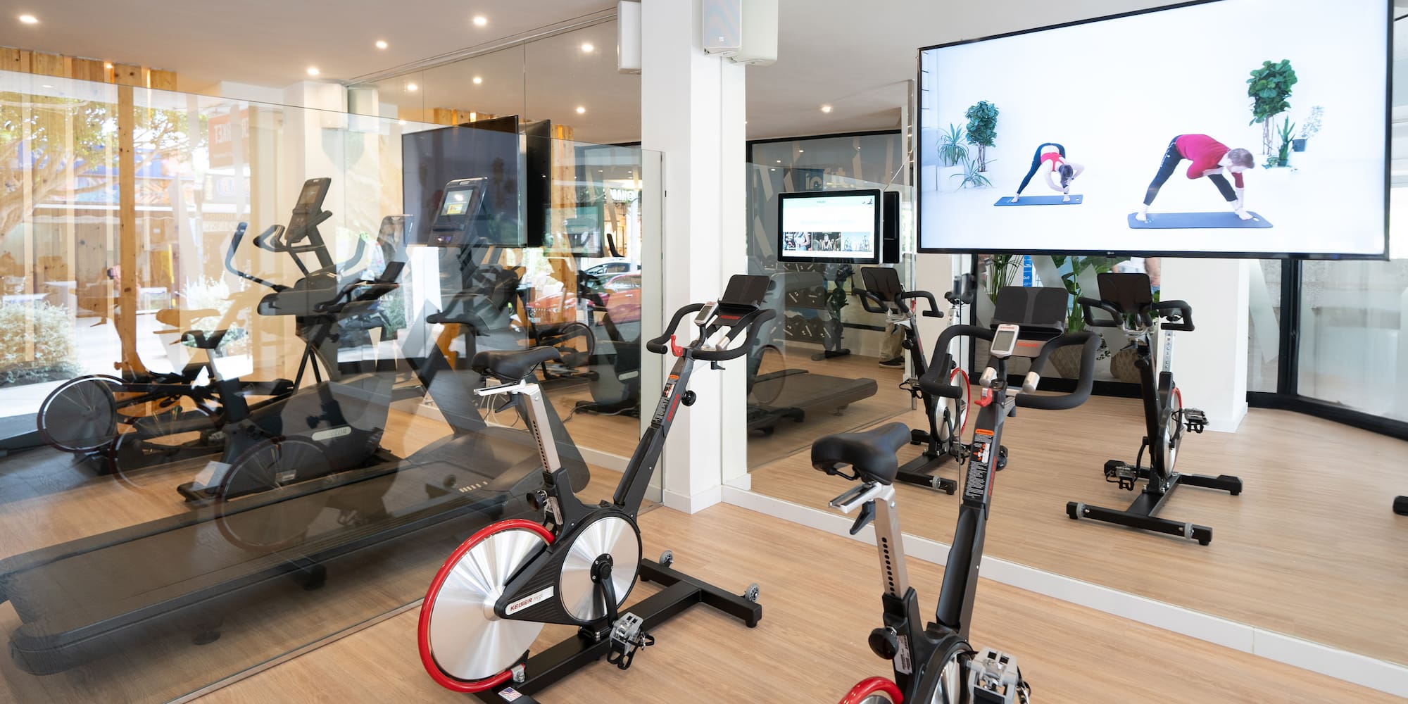 a room with exercise bikes and a large screen