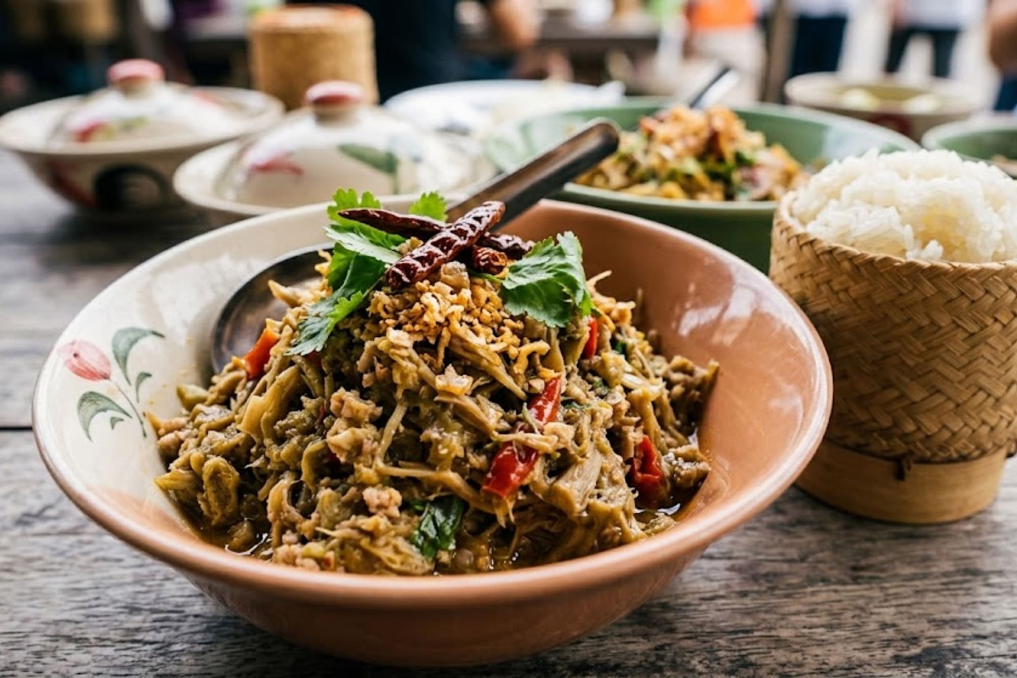 Lao bamboo shoot salad with dried chilies, cilantro, and sticky rice.