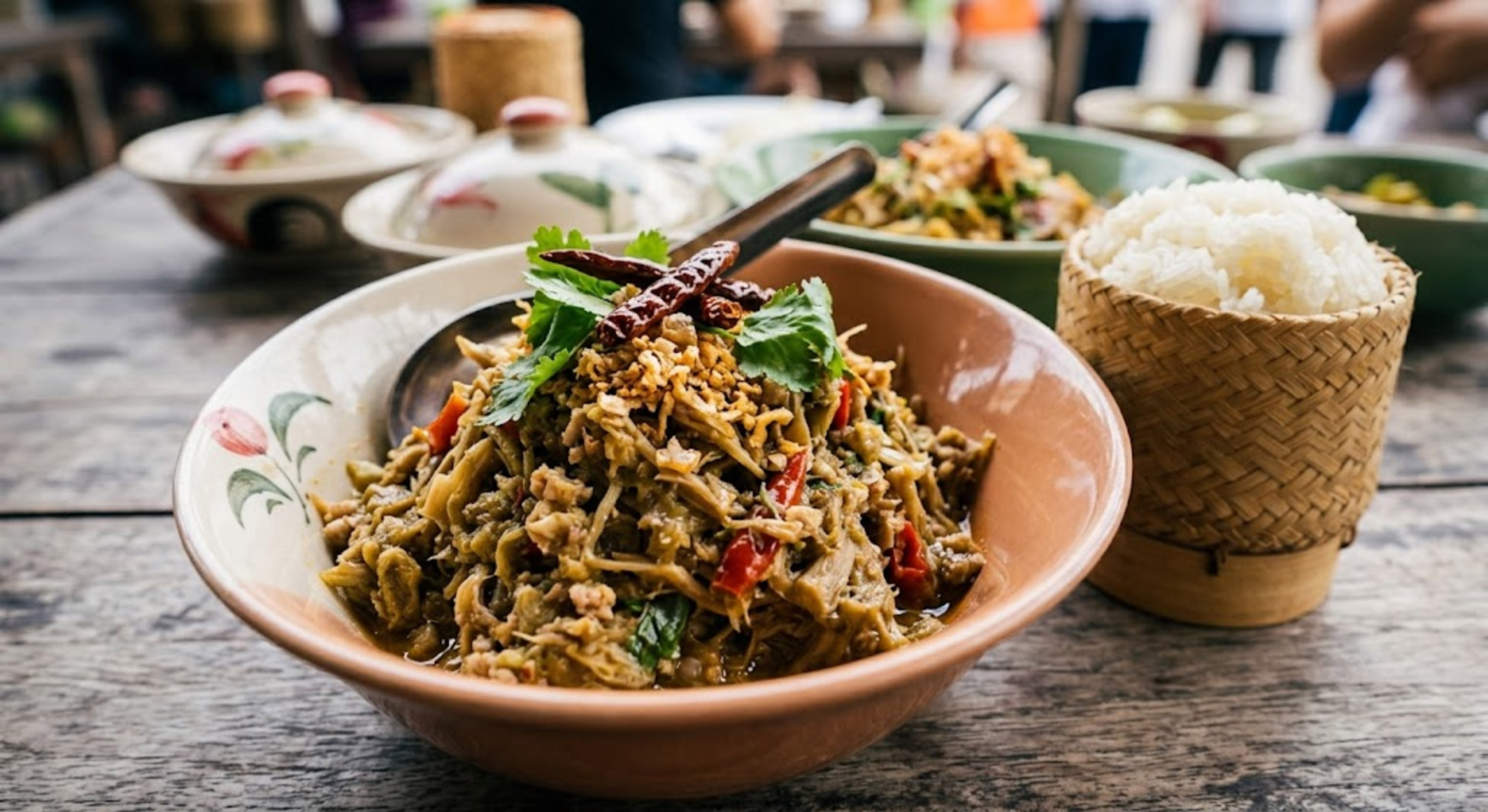 Lao bamboo shoot salad with dried chilies, cilantro, and sticky rice.