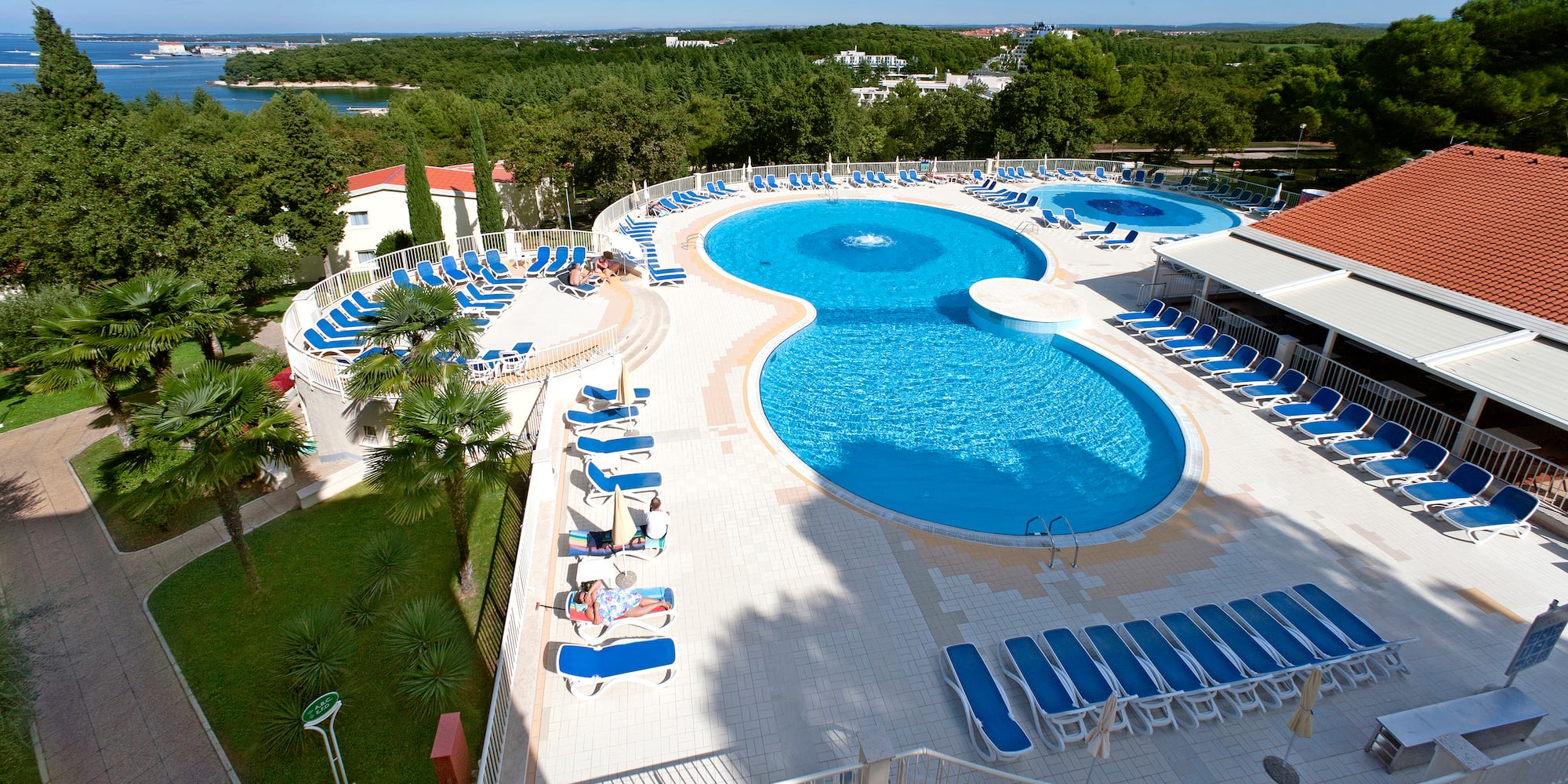 a pool with chairs and trees