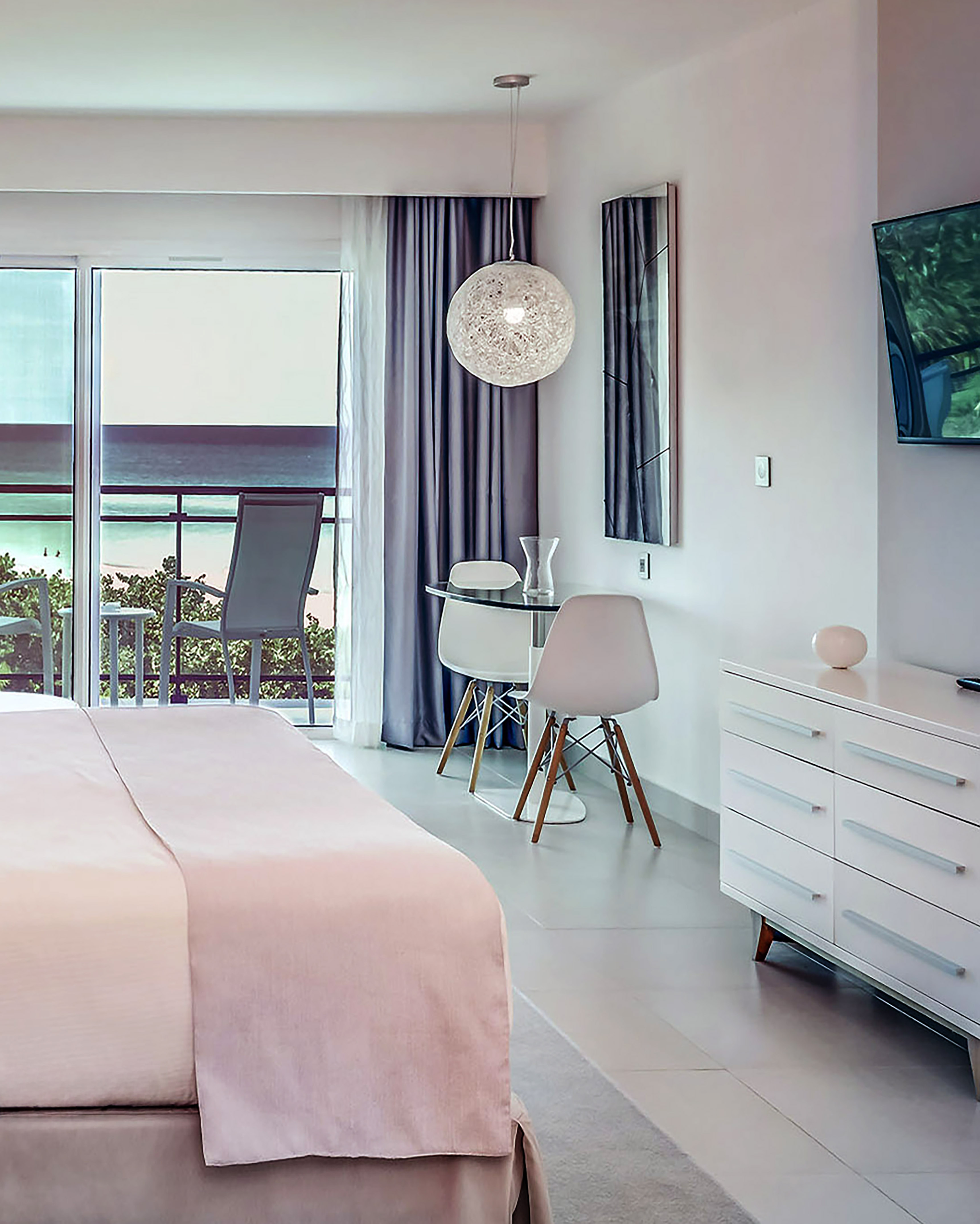 a bedroom with a bed and a desk and chairs