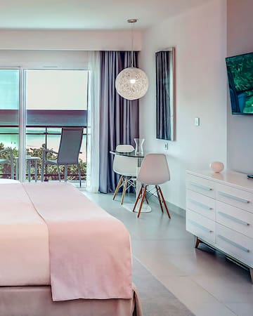 a bedroom with a bed and a desk and chairs