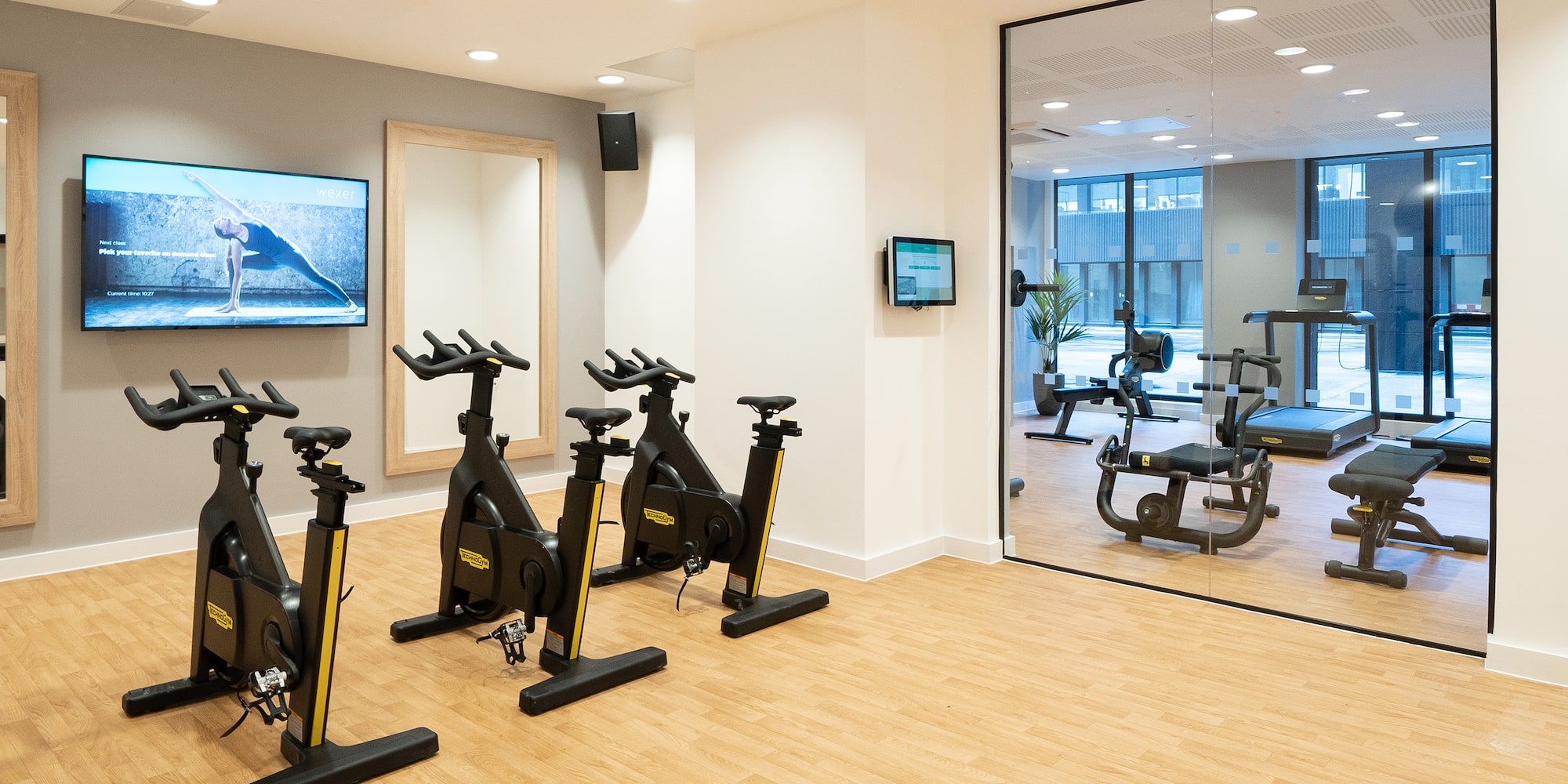 a room with exercise bikes and a mirror