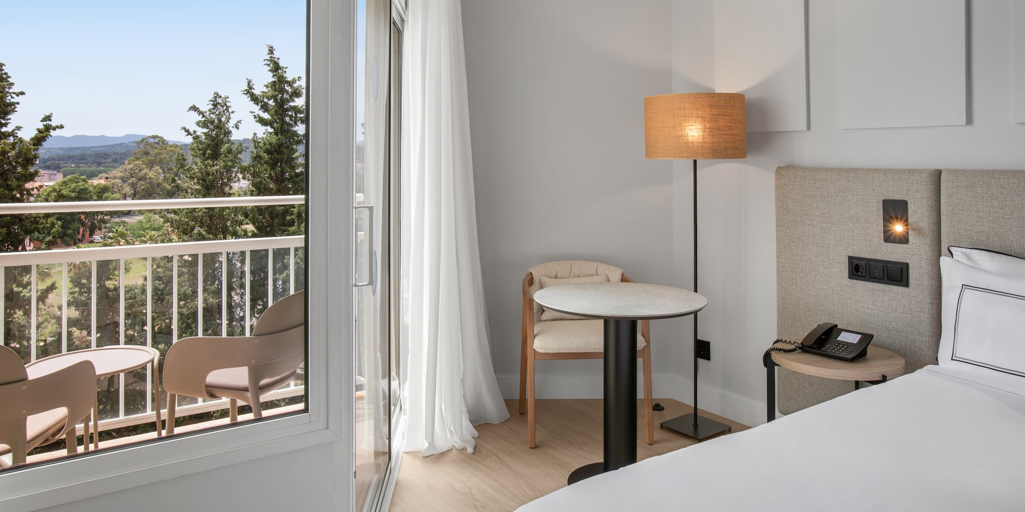 a room with a bed and a table and chairs