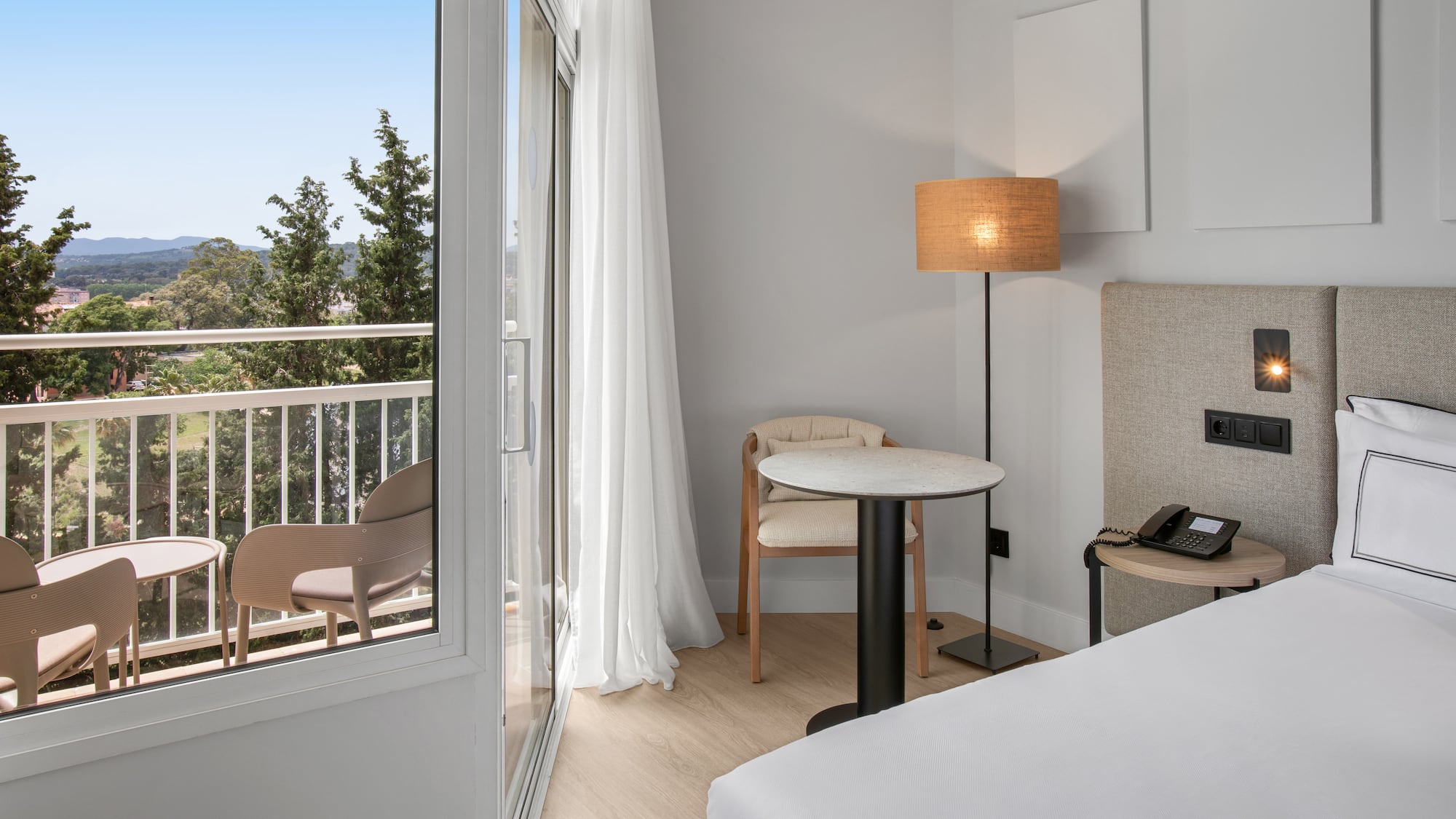 a room with a bed and a table and chairs