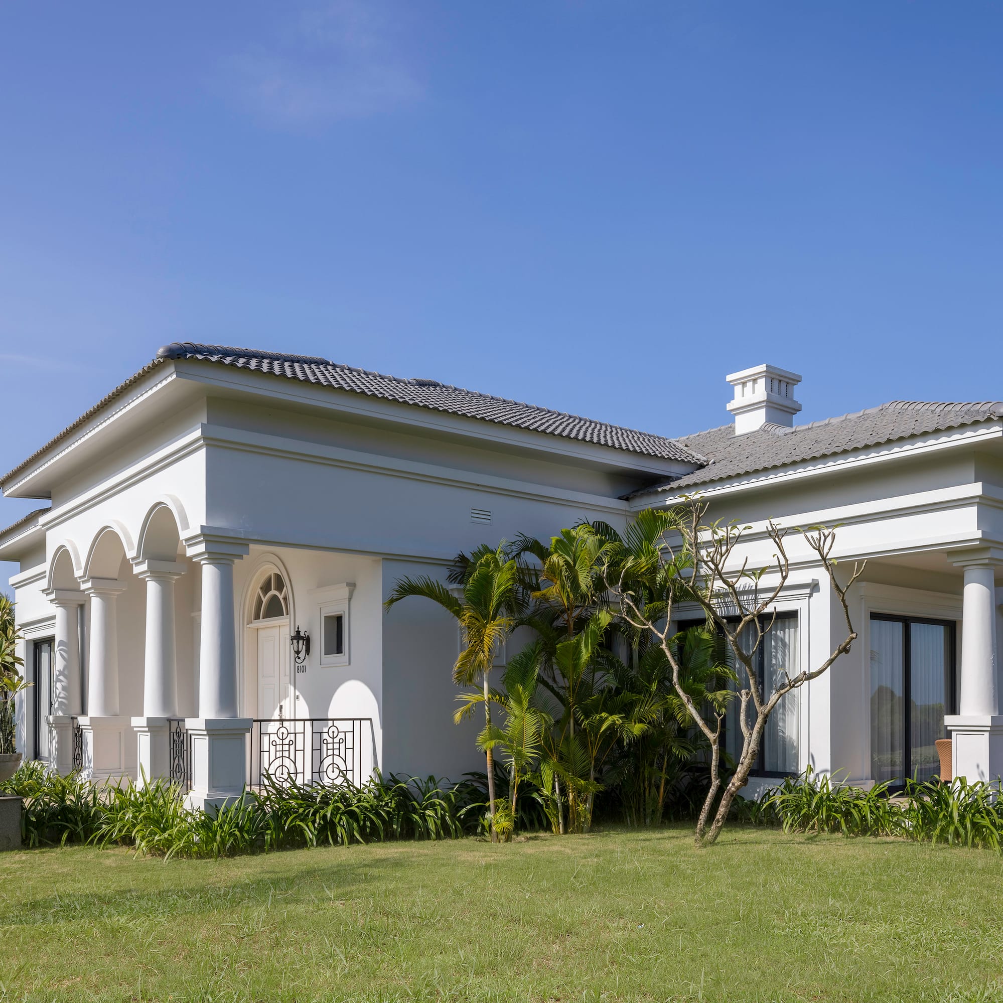 a white house with a lawn and trees