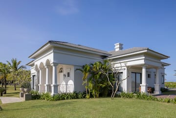 a white house with a lawn and trees