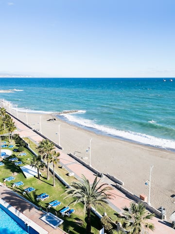 a beach with palm trees and a pool
